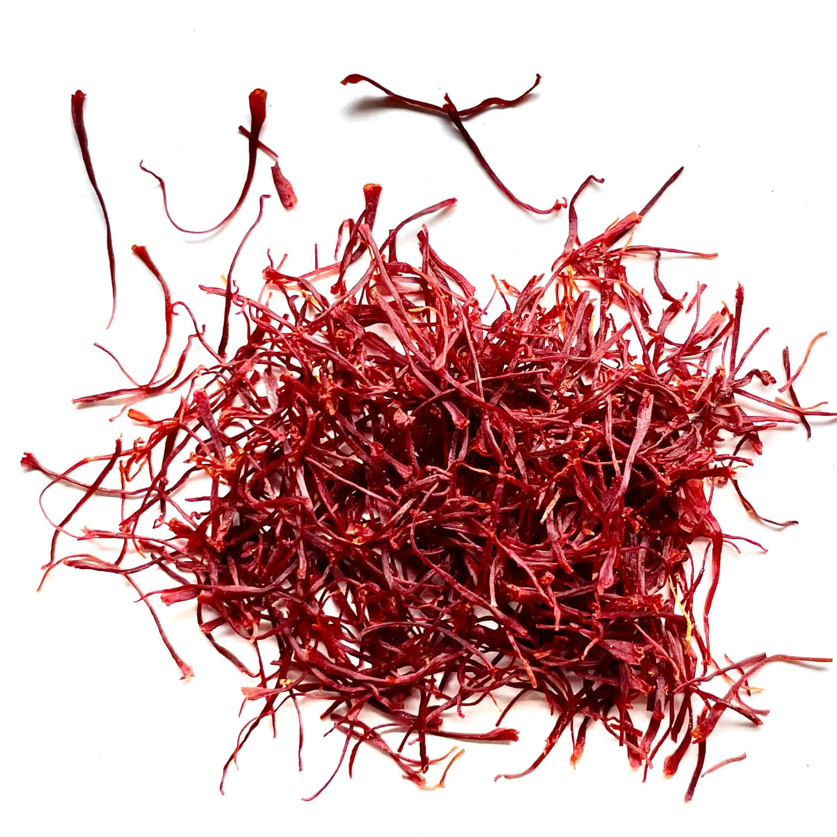 Saffron 桌布 壁紙 — 一堆深紅色番紅花絲散落在純白背景上，色彩鮮明。