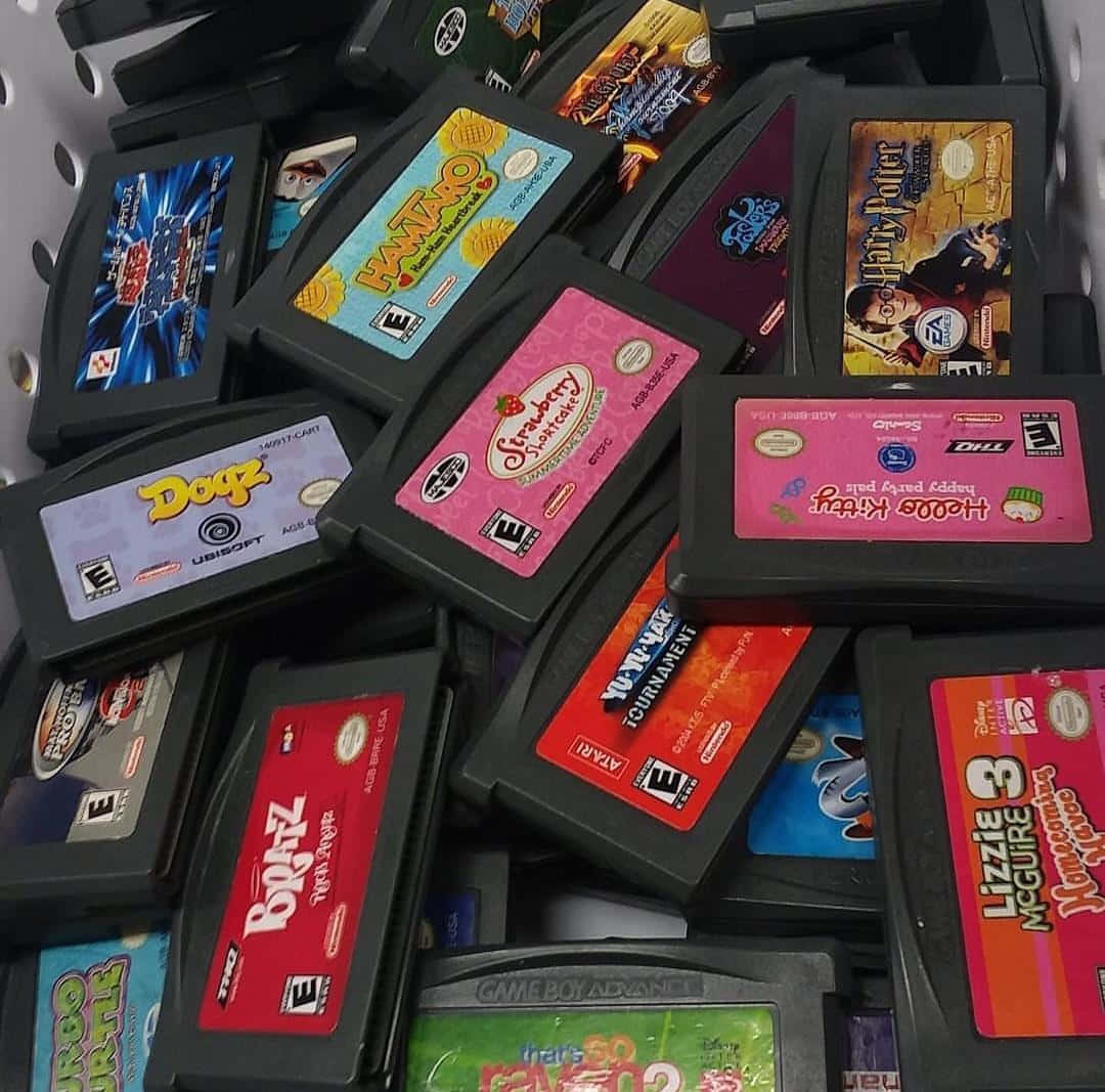2000s 桌布 壁紙 — 一堆混亂的彩色 Game Boy Advance 遊戲卡帶，帶有鮮豔的標籤和多樣的藝術品。
