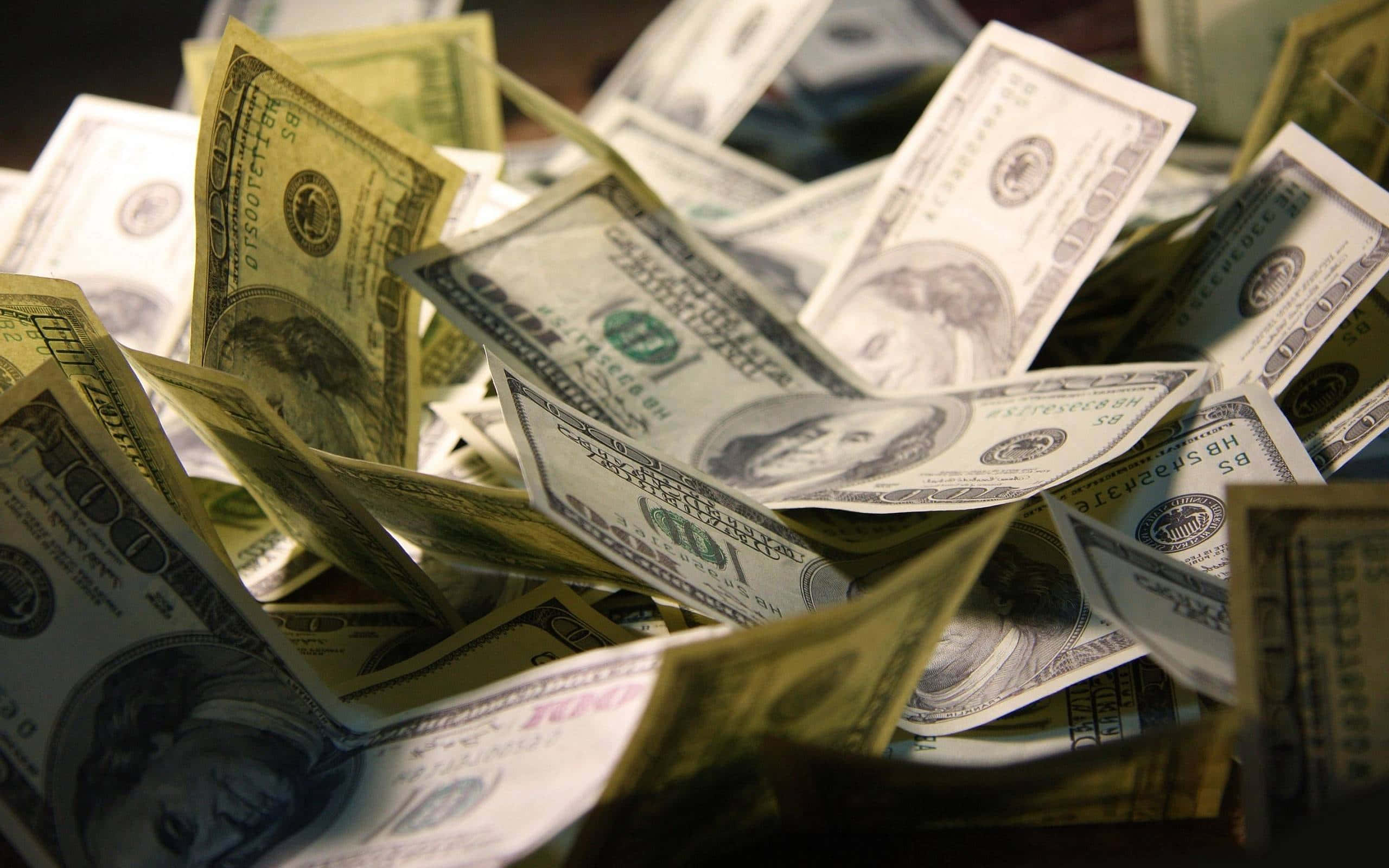 Money Bag 桌布 壁紙 — 一堆混亂的美國一百美元鈔票散亂不堪，前景鈔票清晰對焦。