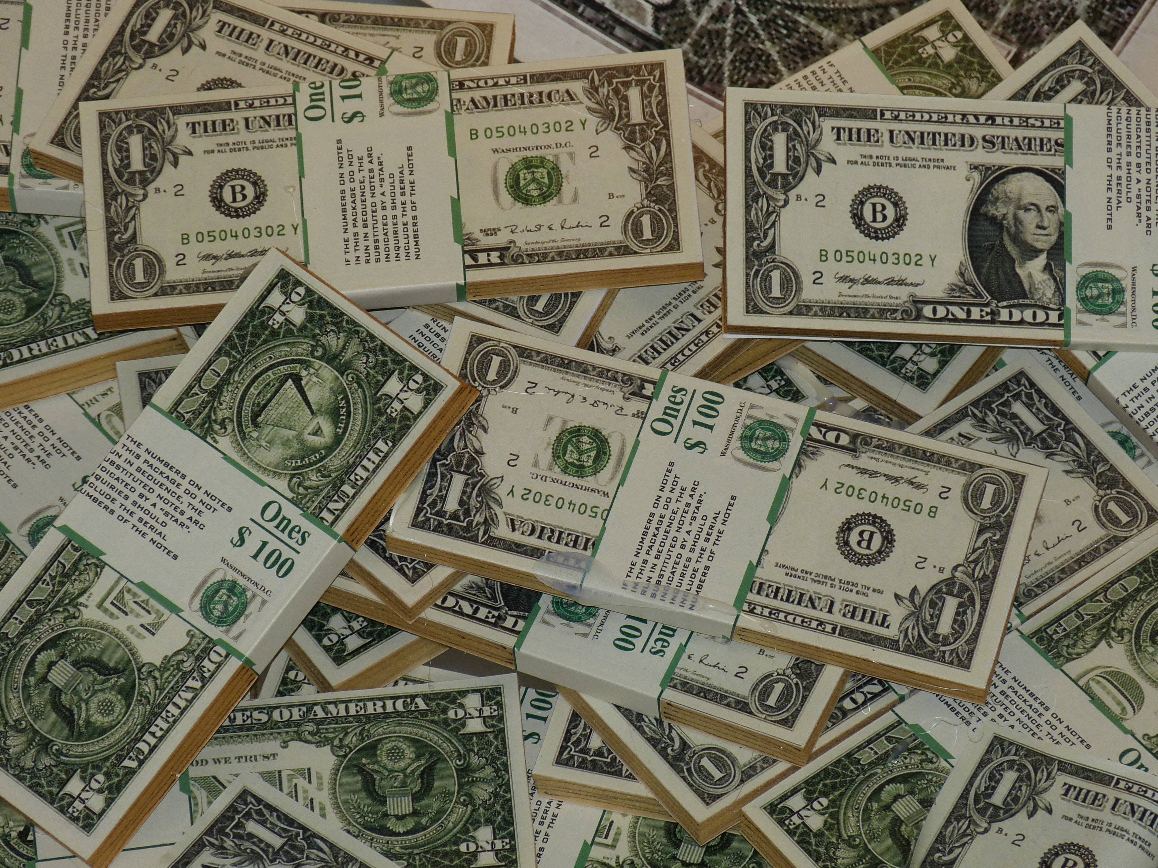 金錢 桌布 壁紙 — 一堆混亂的美國一美元和一百美元鈔票散落在表面上。