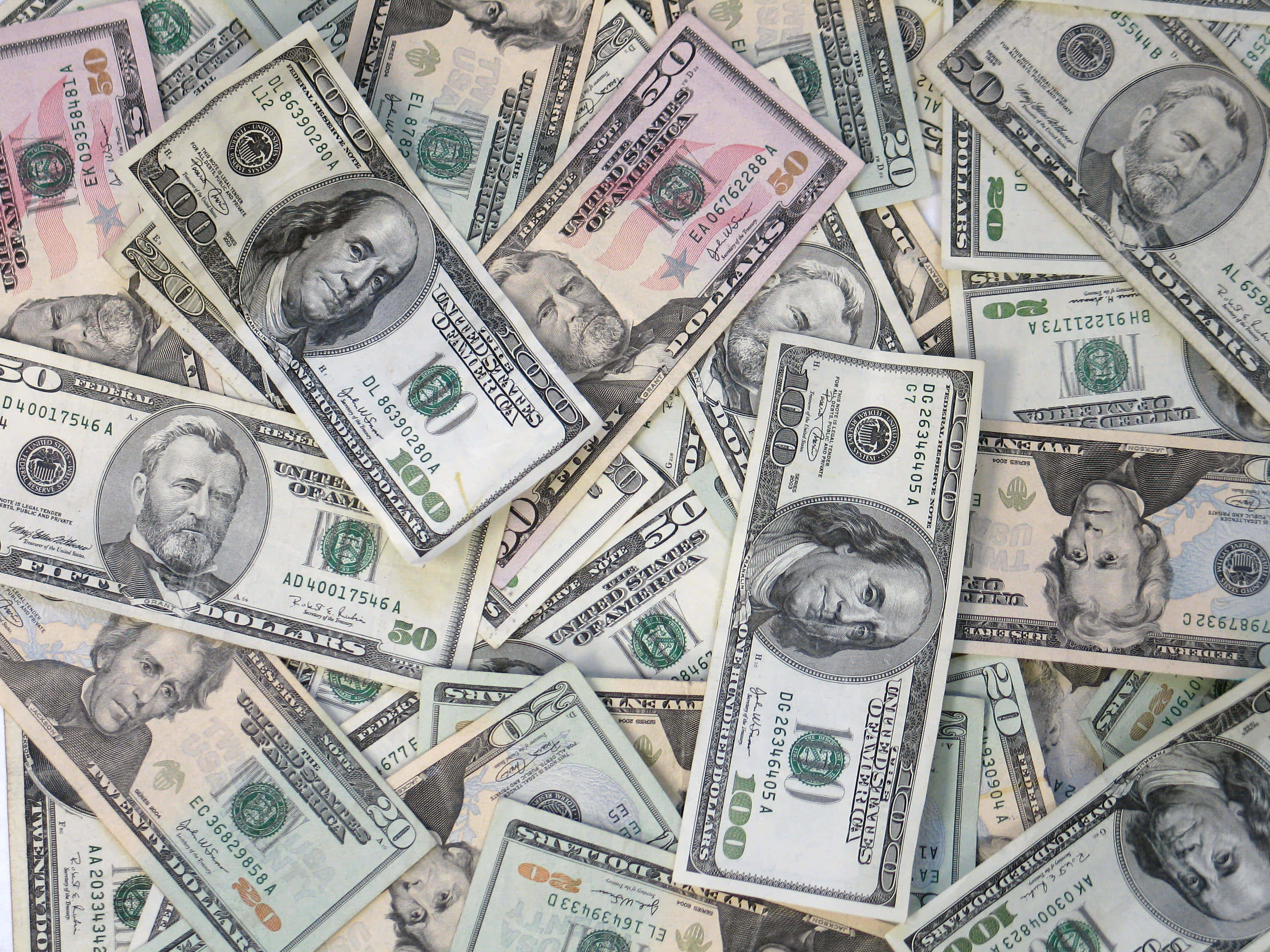 金錢 桌布 壁紙 — 一堆混亂的美國美元鈔票，包括$100、$50和$20面額，散落在整個畫面中。