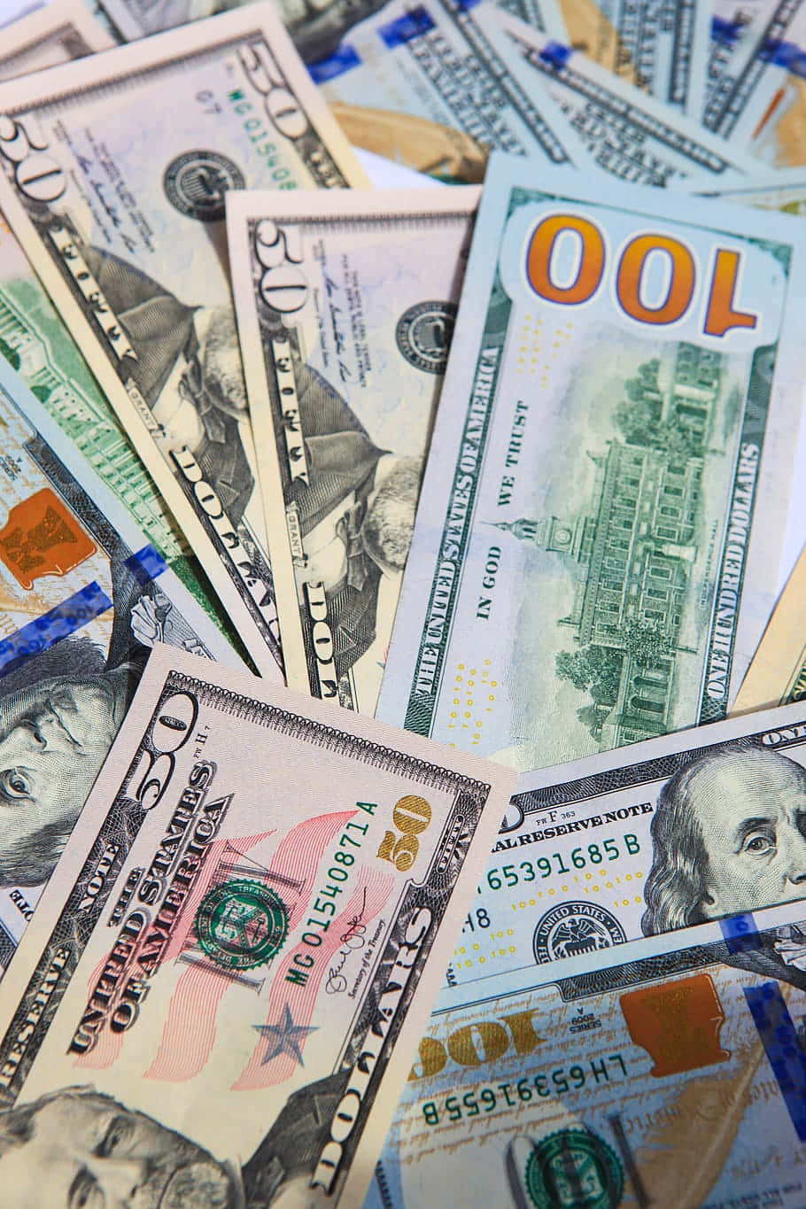 金錢 桌布 壁紙 — 一堆混亂的美國美元鈔票，包括$50、$100和$20面額，清晰聚焦於班傑明·富蘭克林和喬治·華盛頓的臉部。