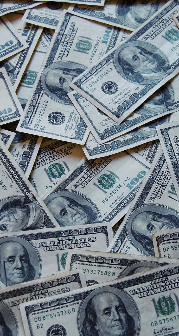 dollar 桌布 壁紙 — 一堆混亂重疊的一百美元鈔票，上面有班傑明·富蘭克林的肖像和綠色墨水細節。