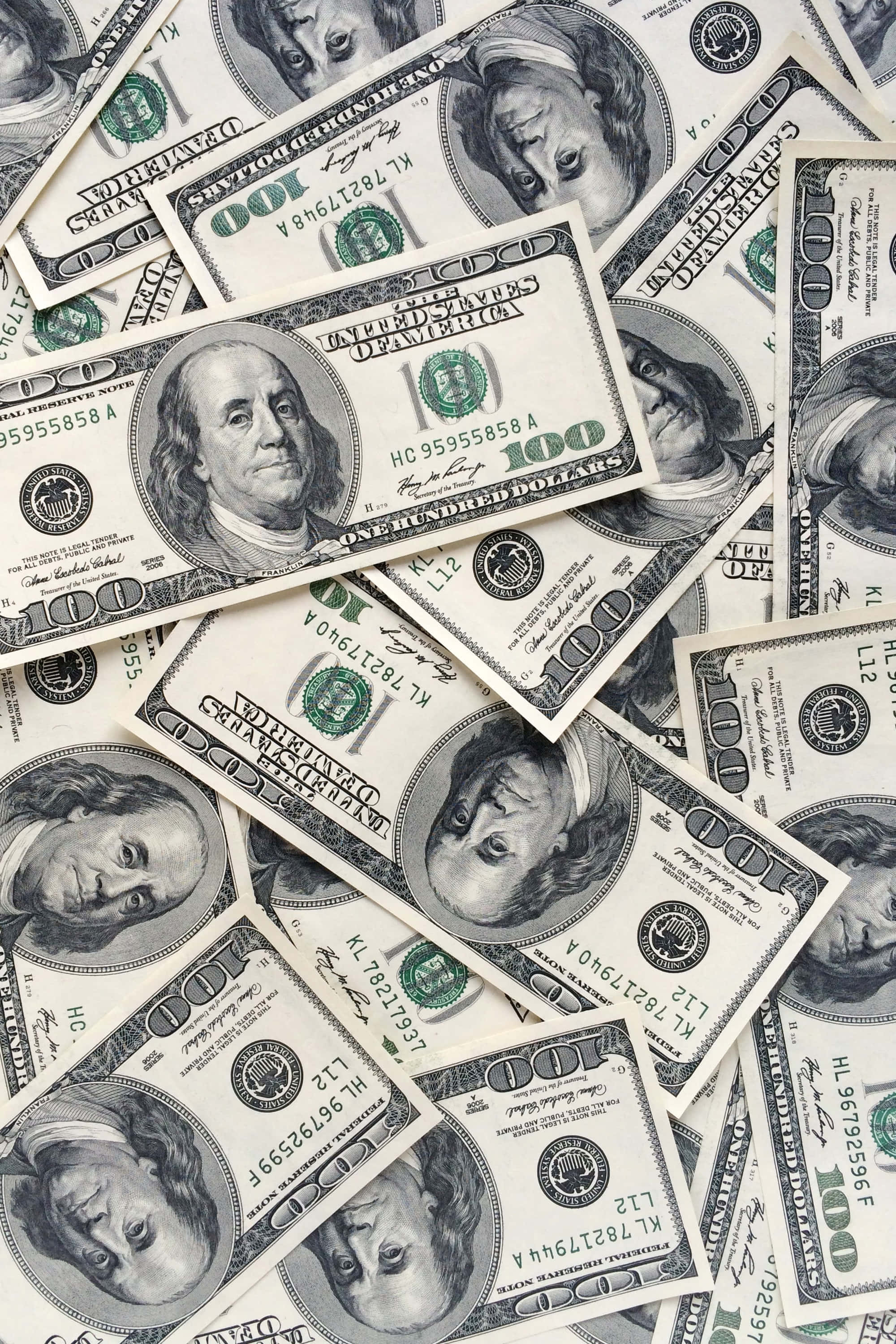 Money 桌布 壁紙 — 一堆混亂重疊的一百美元鈔票，班傑明·富蘭克林的肖像朝上。