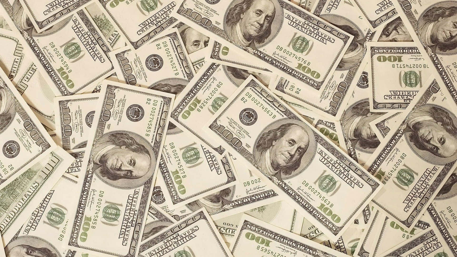 Money 桌布 壁紙 — 一堆混亂重疊的一百美元鈔票，班傑明·富蘭克林的肖像朝上。
