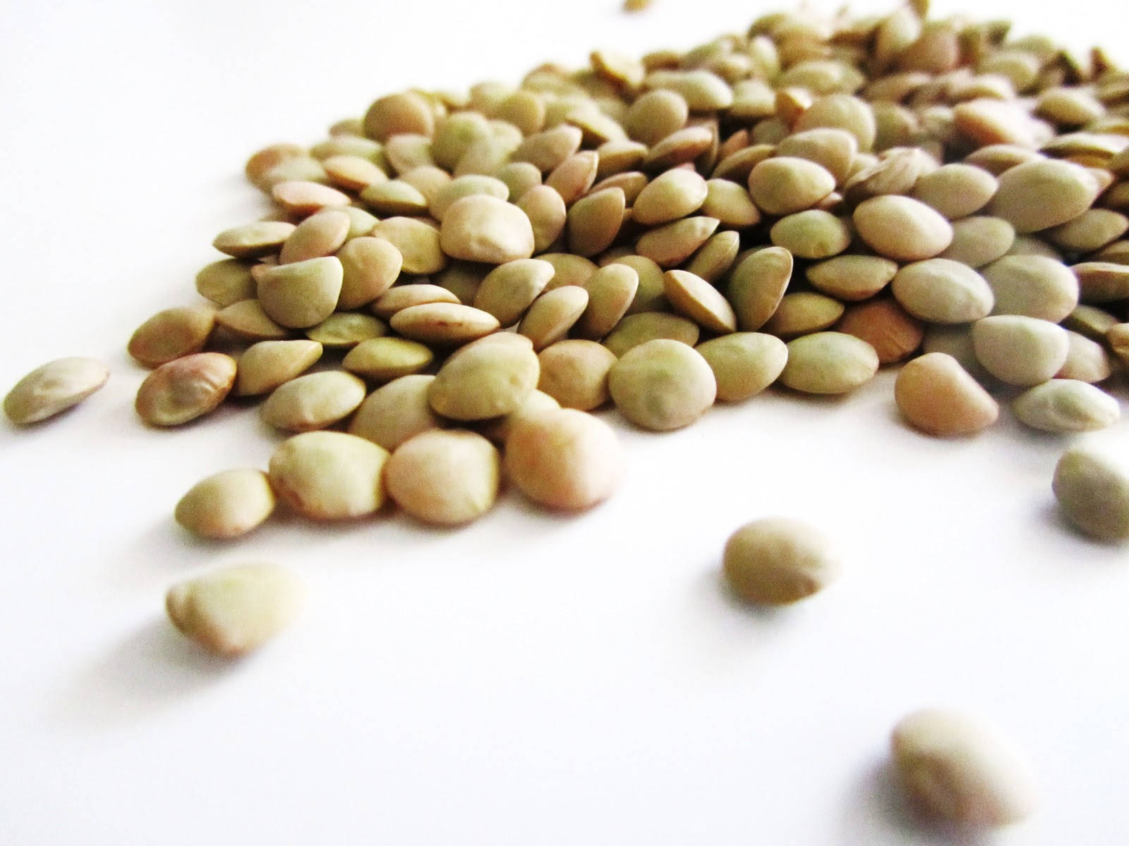 Healthy Food 桌布 壁紙 — 一堆淺綠色扁豆散落在明亮的白色表面上，帶有柔和陰影的特寫。