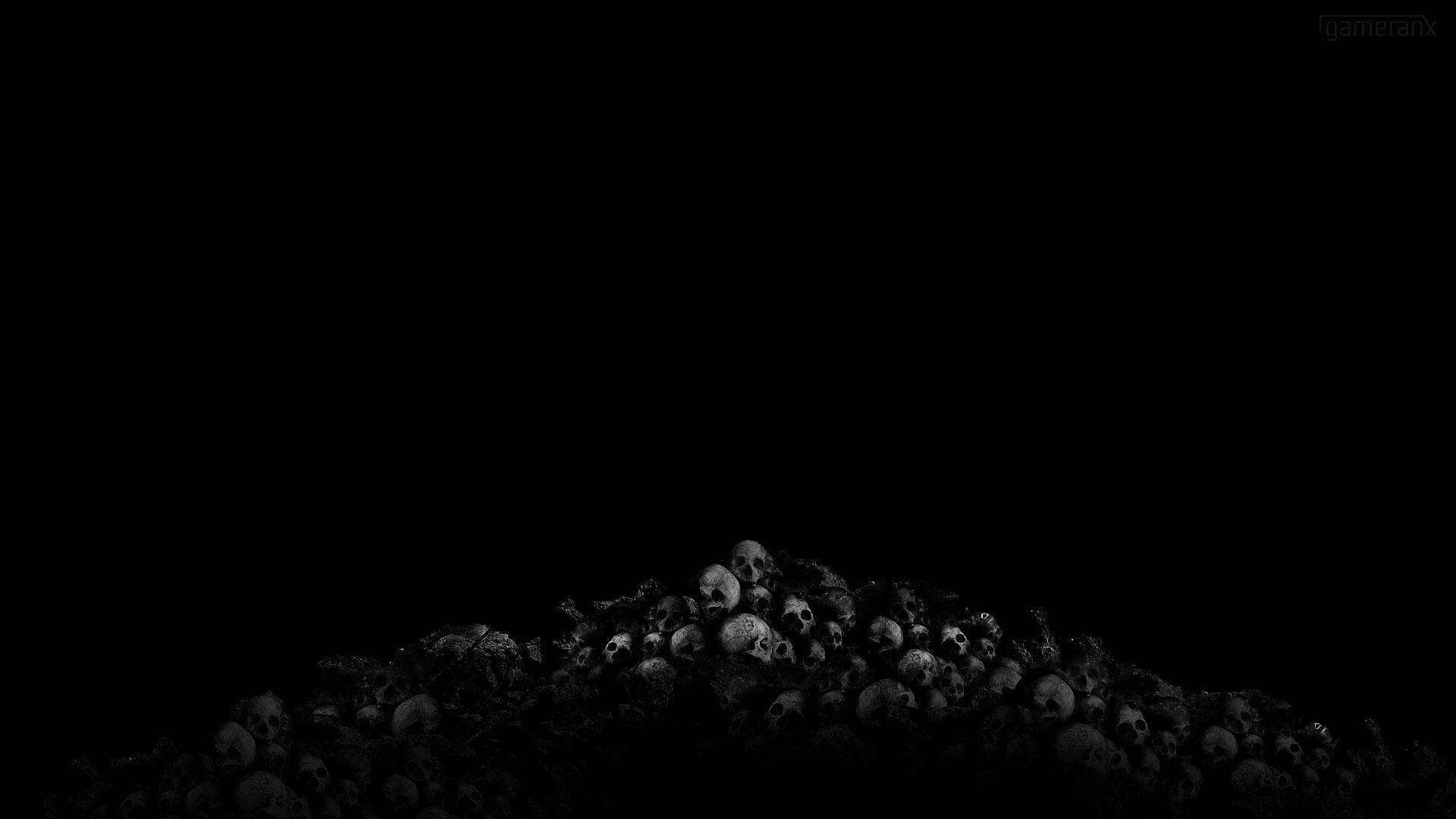 skulls 桌布 壁紙 — 一堆清晰的頭骨從絕對的黑暗中浮現，營造出令人難忘且不祥的視覺效果。