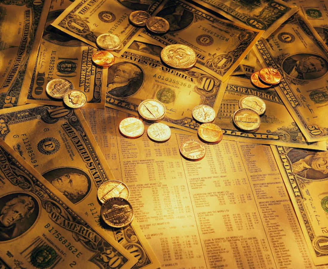 金錢 桌布 壁紙 — 一堆溫暖金色的美元紙幣和硬幣散落在財務試算表上。