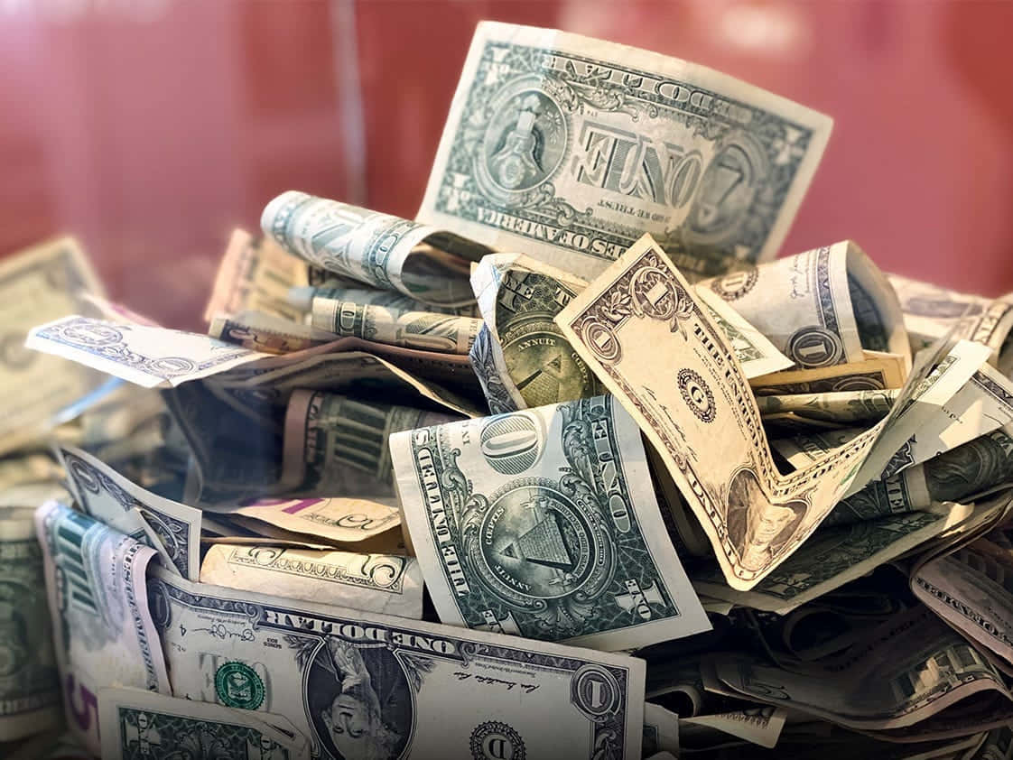 Money Falling 桌布 壁紙 — 一堆皺巴巴的一美元鈔票散落在紅色表面上，景深很淺。