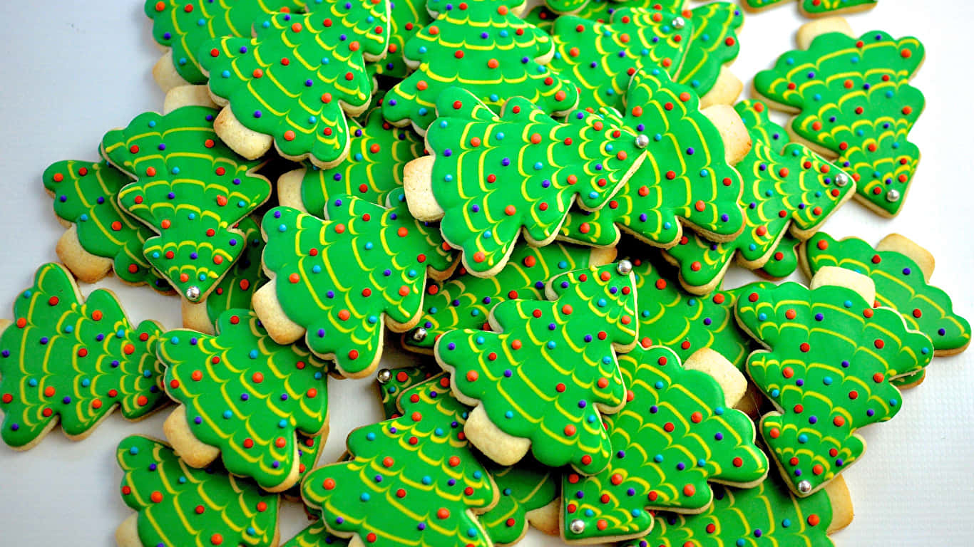 1366x768 Cookies 桌布 壁紙 — 一堆節日綠色聖誕樹形狀的糖餅乾，裝飾著彩色糖粒和黃色糖霜。