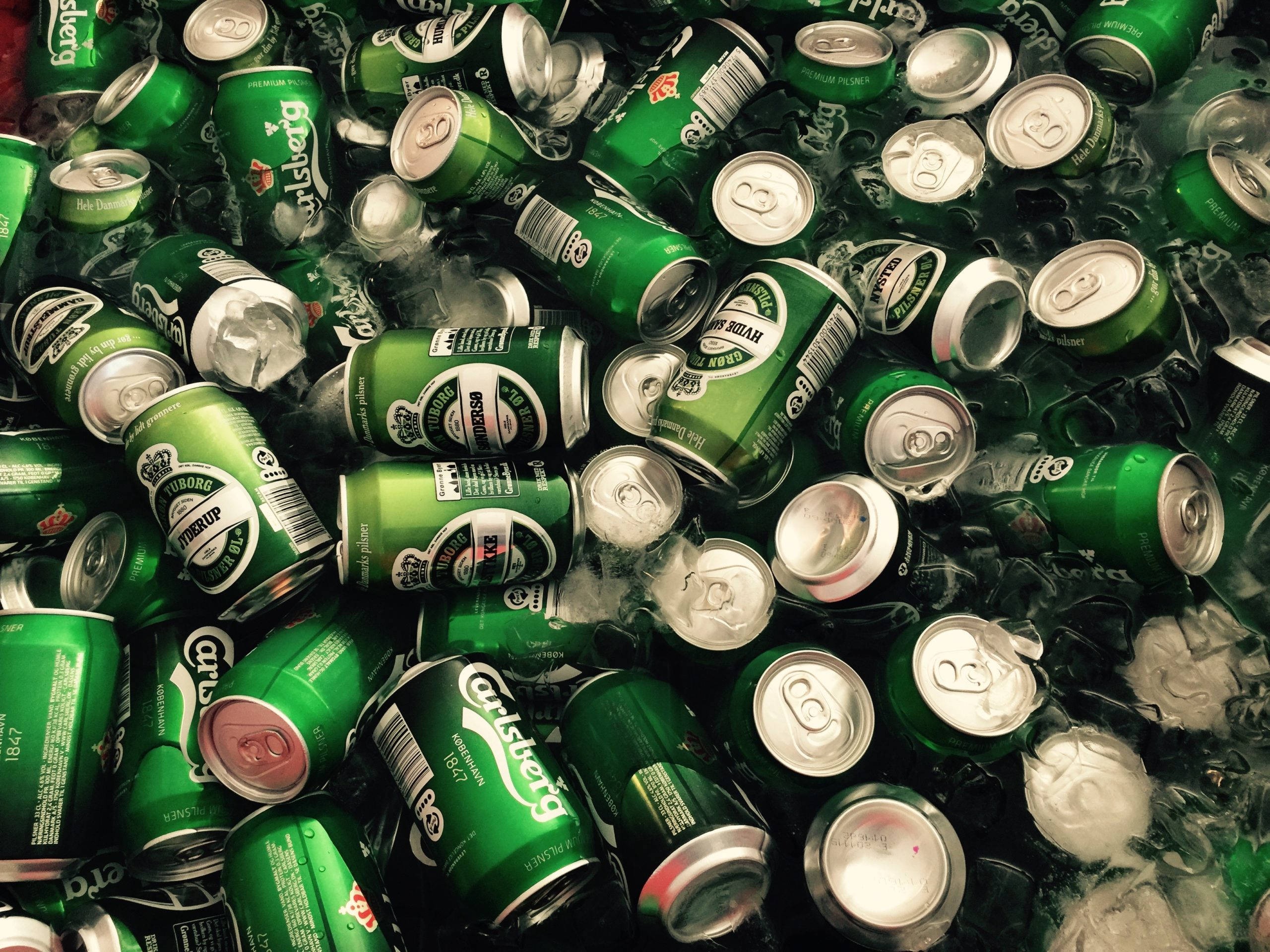 Beer 桌布 壁紙 — 一堆綠色嘉士伯啤酒罐緊密地堆放在融冰中，凝結的水珠滴落。