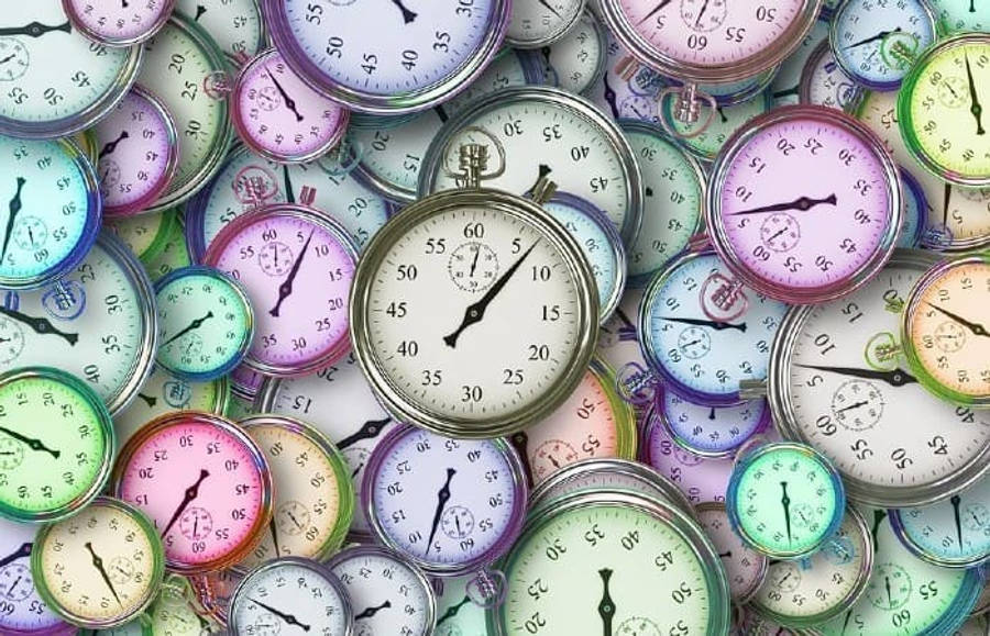 Clock 桌布 壁紙 — 一堆色彩繽紛的復古計時器混亂地堆疊，各種錶盤和指針以密集圖案重疊。