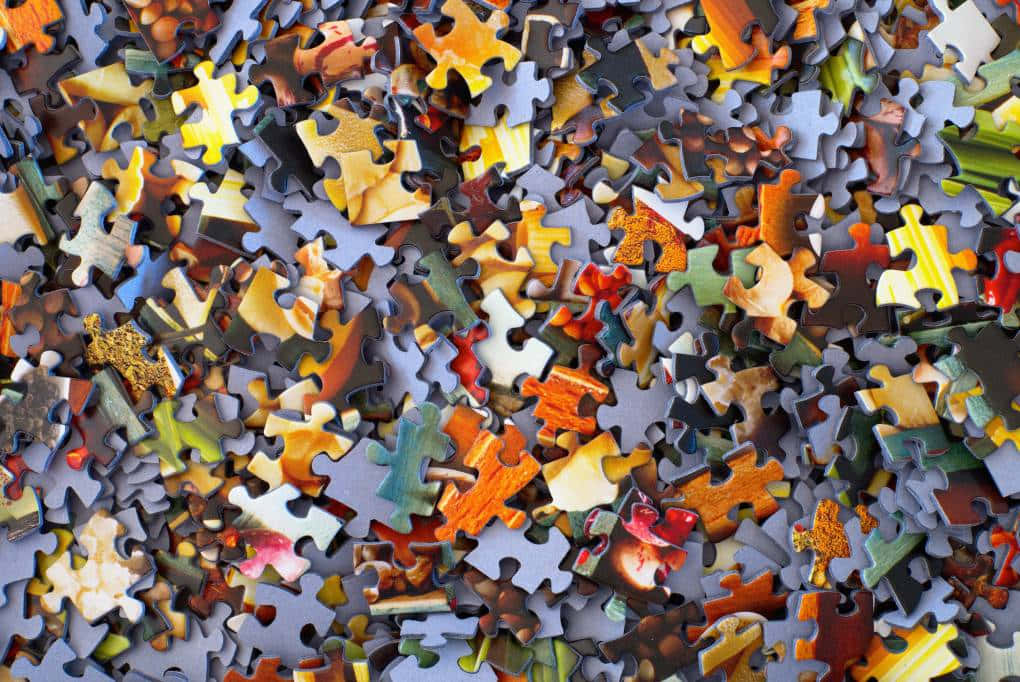 Puzzle 桌布 壁紙 — 一堆色彩繽紛的拼圖碎片雜亂無章地散落，形成一片鮮明而未經整理的混亂。