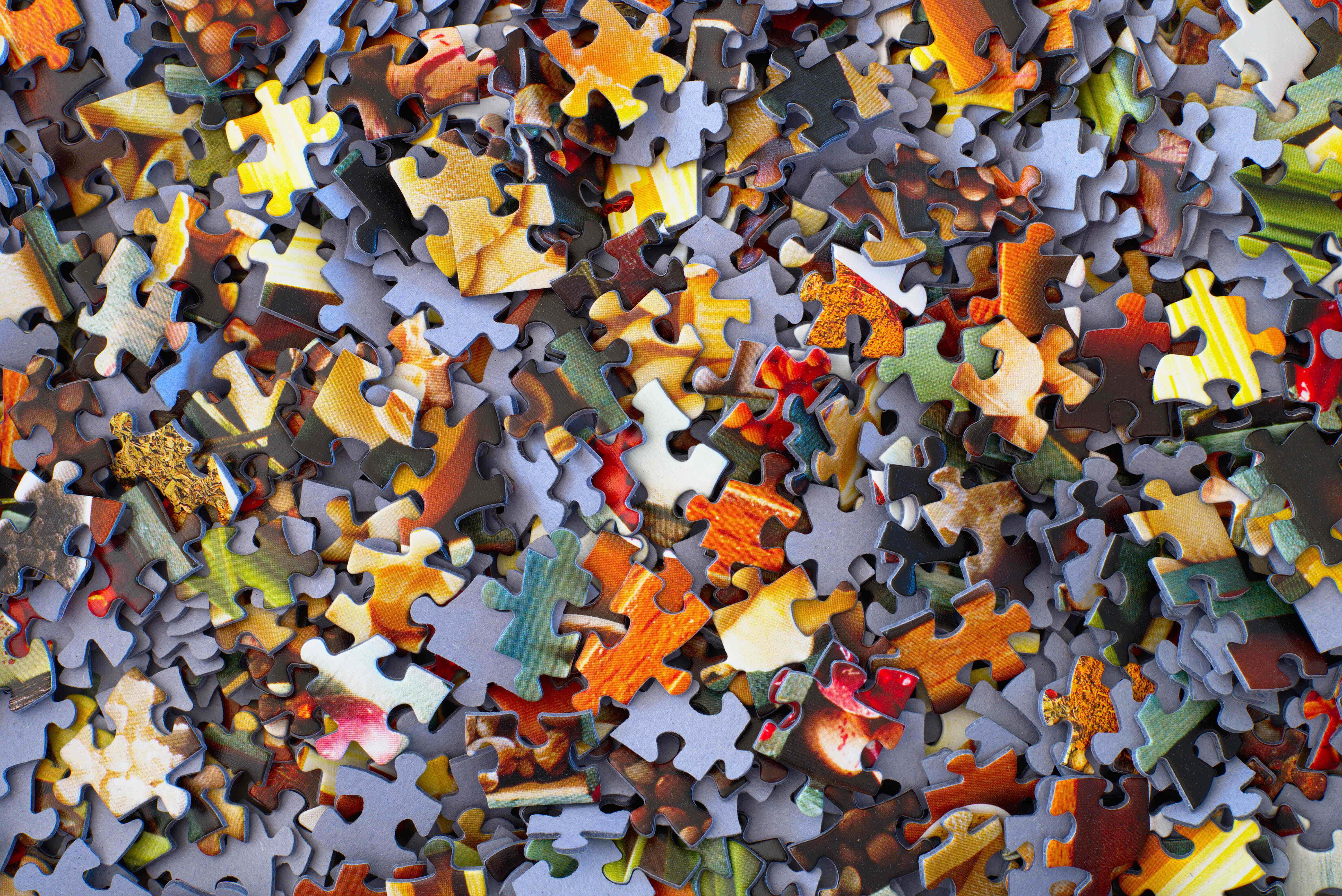 Puzzle Games 桌布 壁紙 — 一堆色彩繽紛的拼圖碎片雜亂無章地散落，形成一片混亂而鮮明的景象。