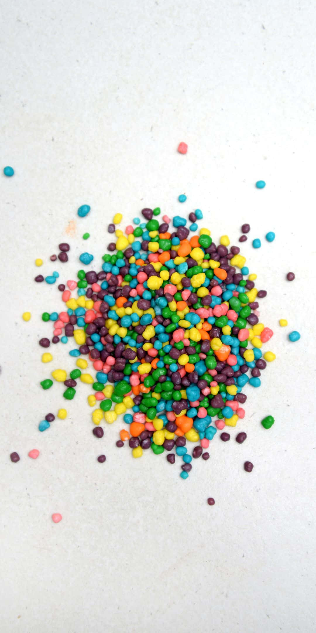 Sprinkles 桌布 壁紙 — 一堆色彩繽紛的糖霜灑在純白表面上。