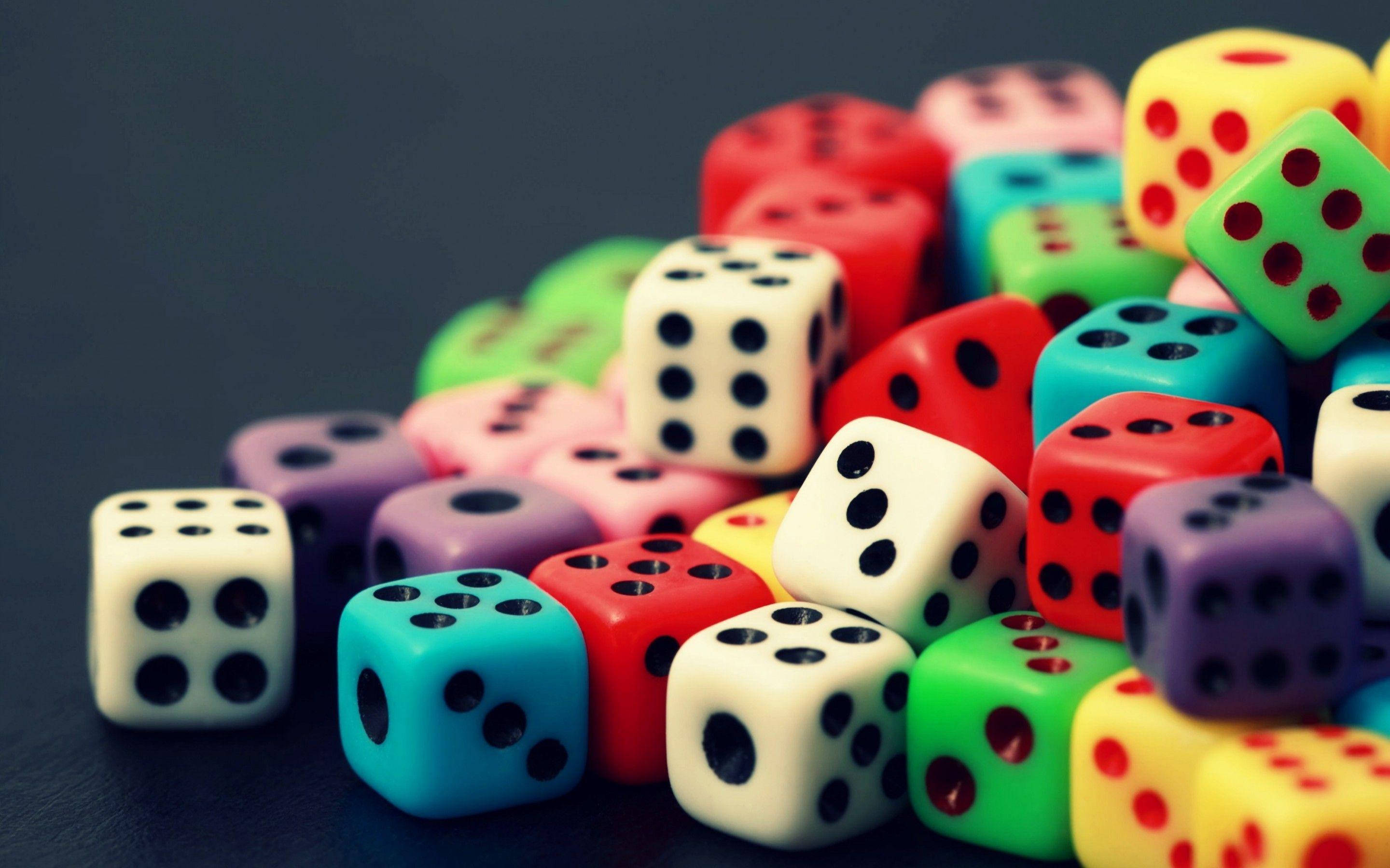 Gambar 桌布 壁紙 — 一堆色彩繽紛的骰子散落在深色表面上，景深較淺。