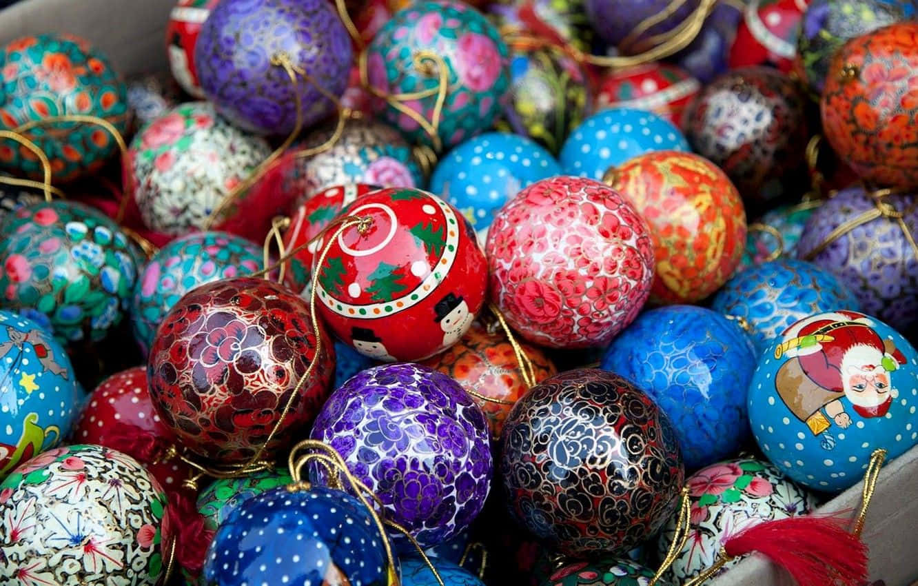 Christmas Ornament 桌布 壁紙 — 一堆色彩鮮豔、繪製精緻的裝飾性飾物，帶有節日圖案和金線。