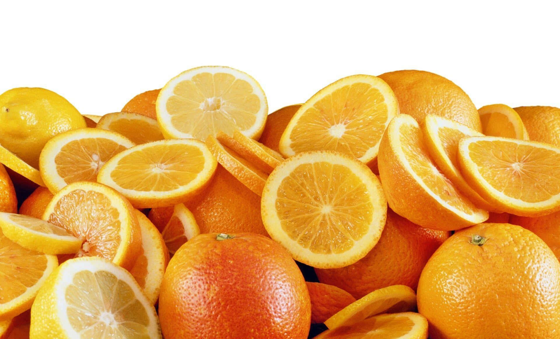 Orange Fruit 桌布 壁紙 — 一堆色彩鮮豔的完整和切片柳橙及檸檬，在純白背景上迸發出多汁的色彩。