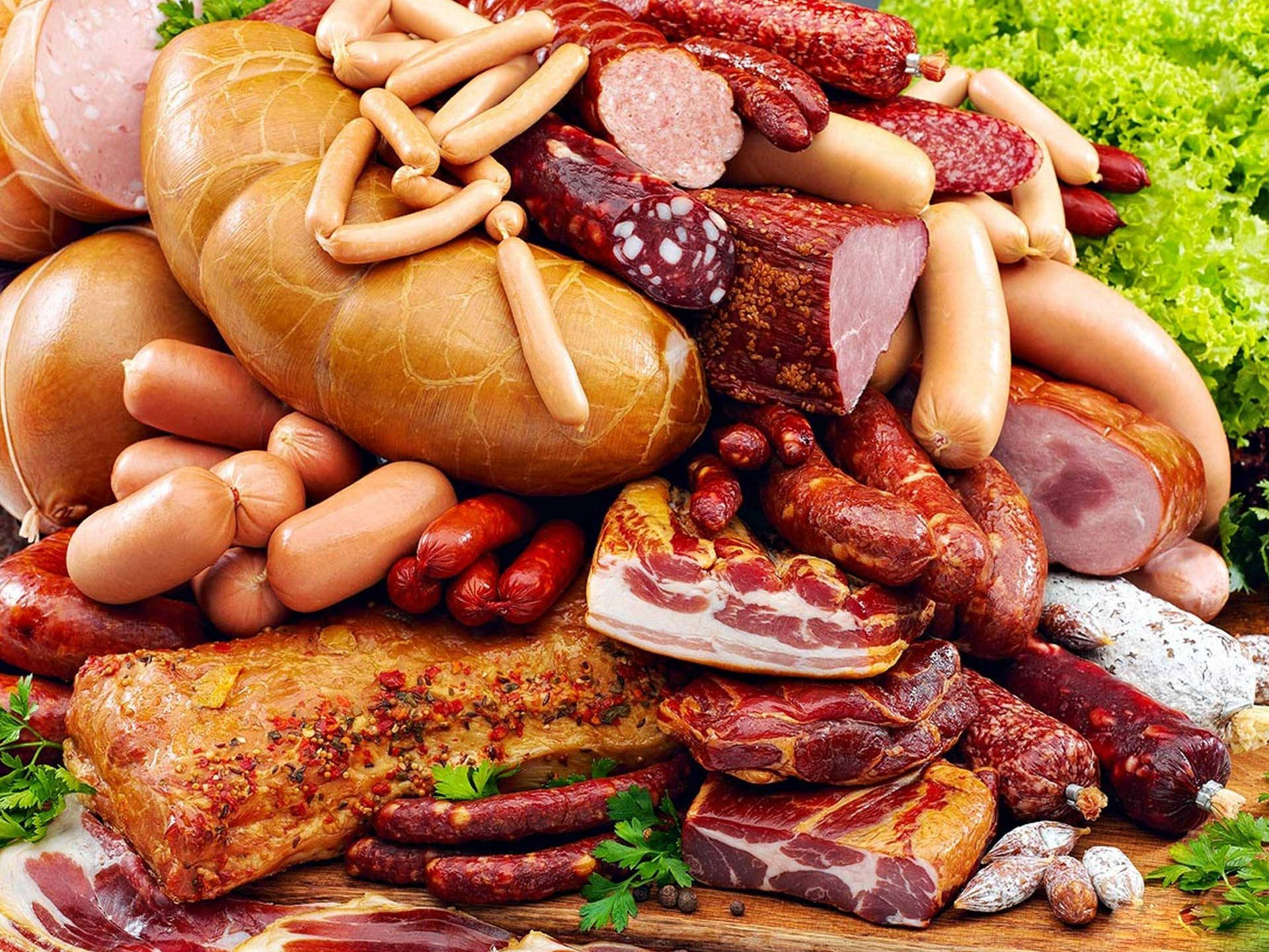 meat 桌布 壁紙 — 一堆豐盛的各式醃製肉類、香腸和培根，用新鮮香草點綴，放在質樸的木板上。