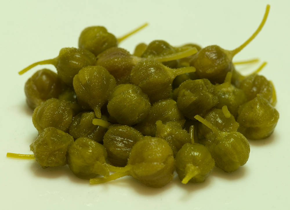 Fruit 桌布 壁紙 — 一堆近距離拍攝的綠色酸豆，帶有細膩的莖，背景為純白色。