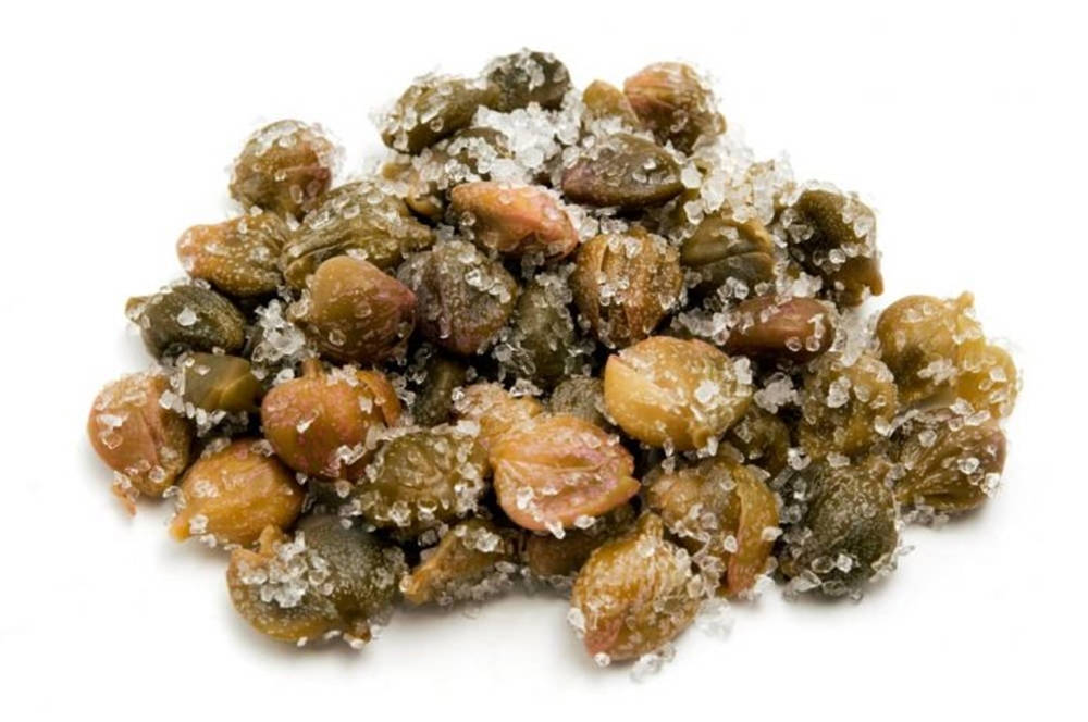 salt 桌布 壁紙 — 一堆醃漬酸豆的特寫，在純白背景下閃爍著粗鹽的光澤。