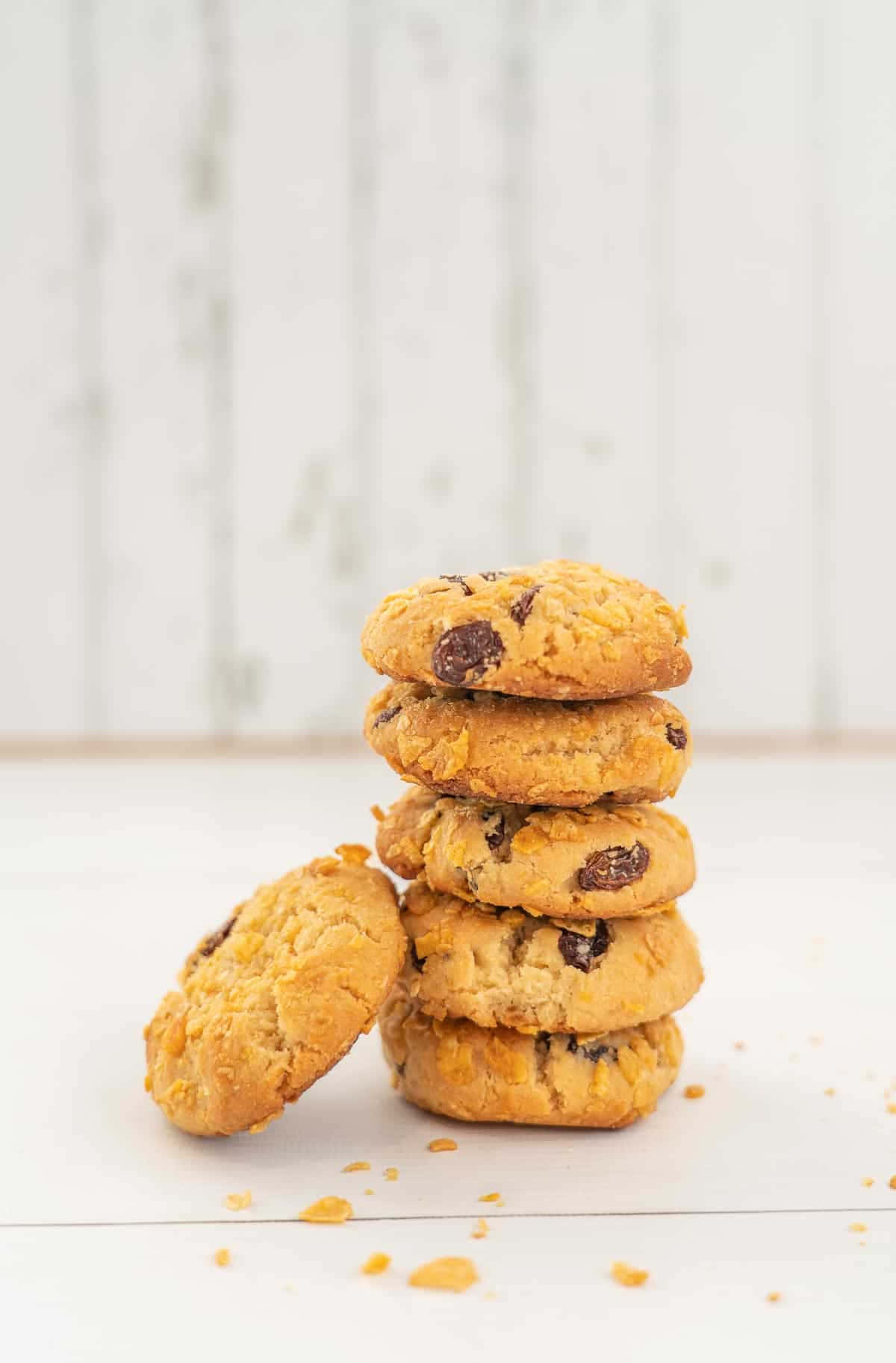 Cookies 桌布 壁紙 — 一堆金黃色的巧克力餅乾，其中一塊斜靠在旁邊的白色木質表面上。