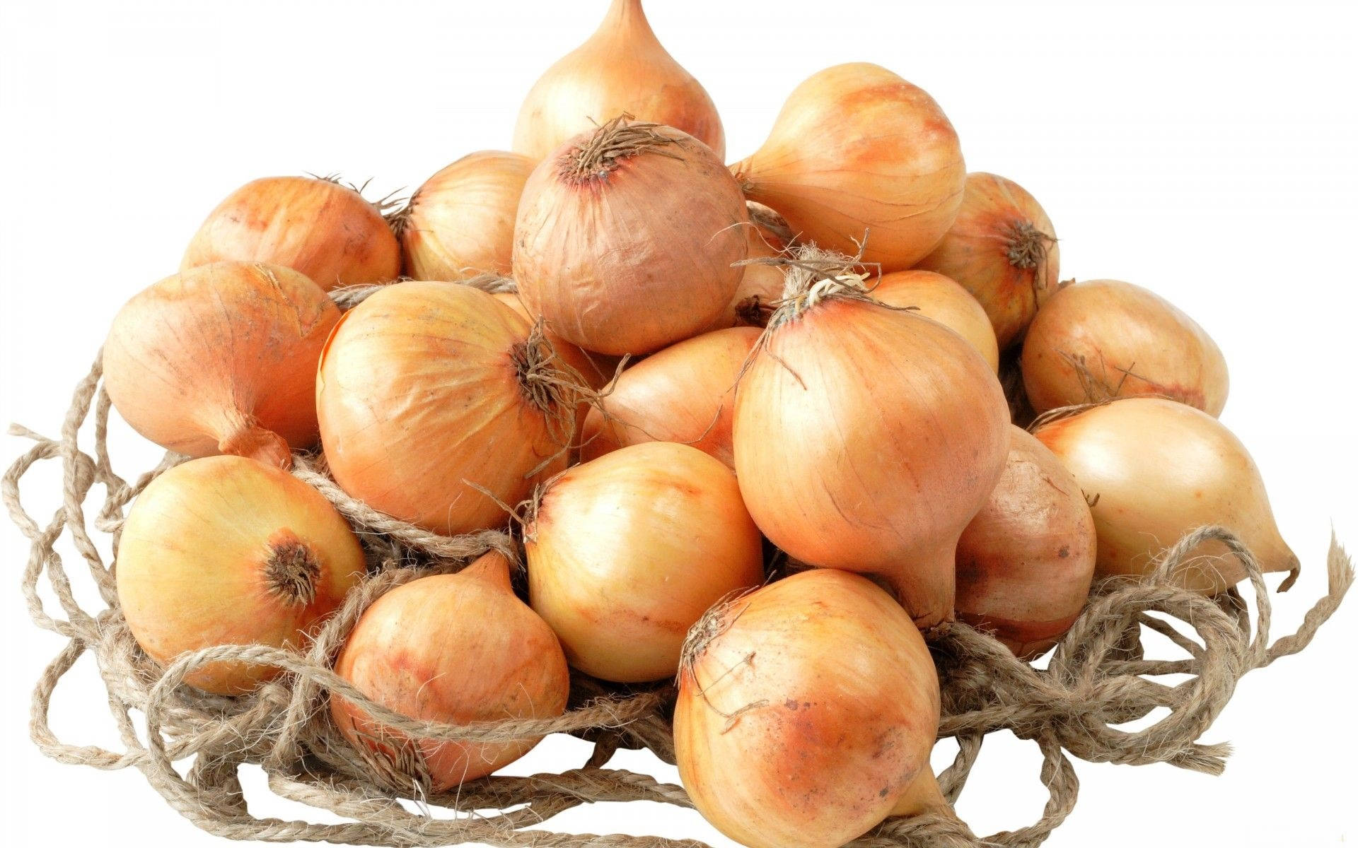 Onion 桌布 壁紙 — 一堆金黃色的洋蔥放在一個質樸的編織繩籃中，背景是純白色。