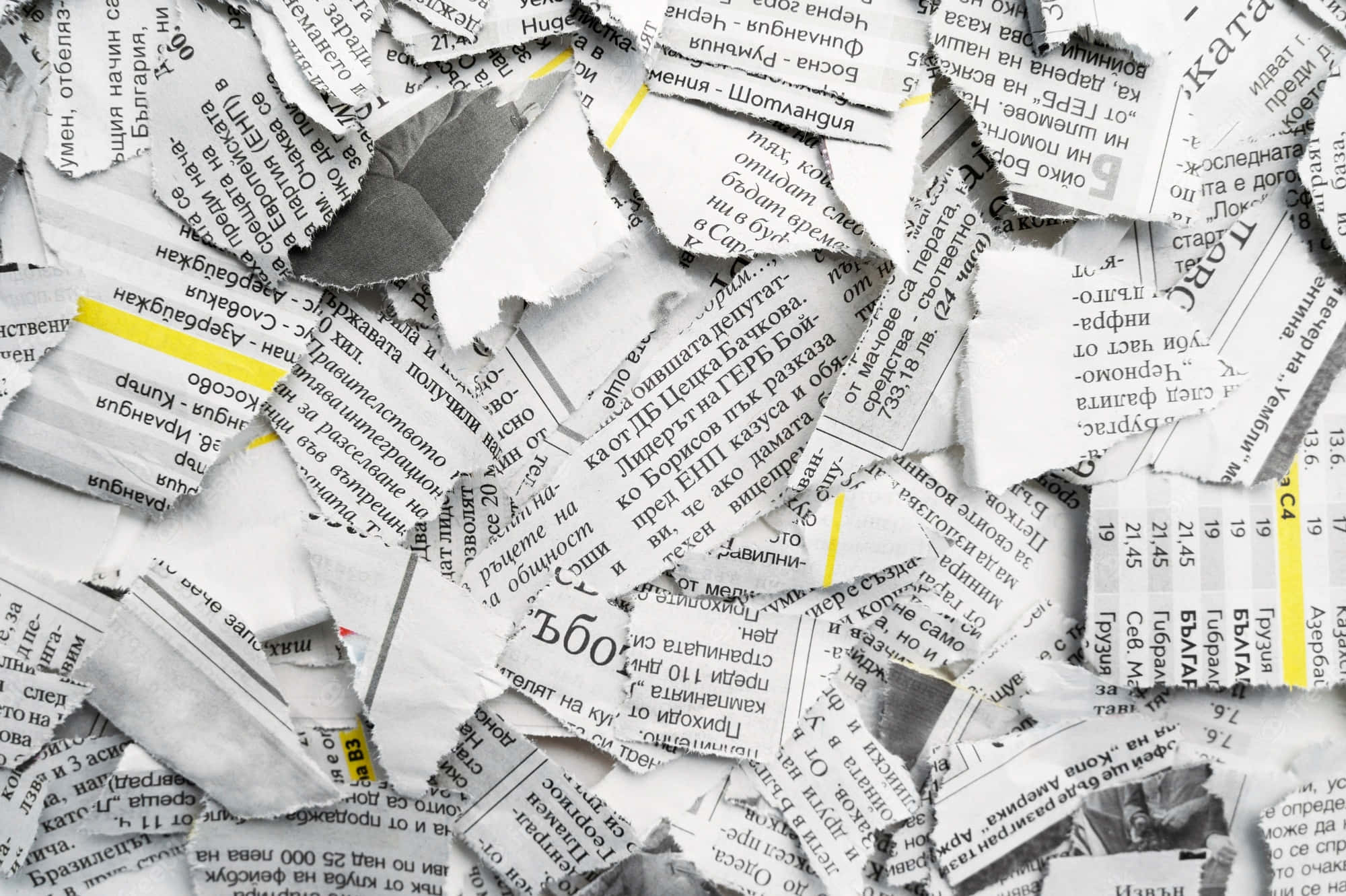 Newspaper 桌布 壁紙 — 一堆雜亂的撕碎報紙碎片，帶有西里爾文字和黃色高亮，散落在畫面中。