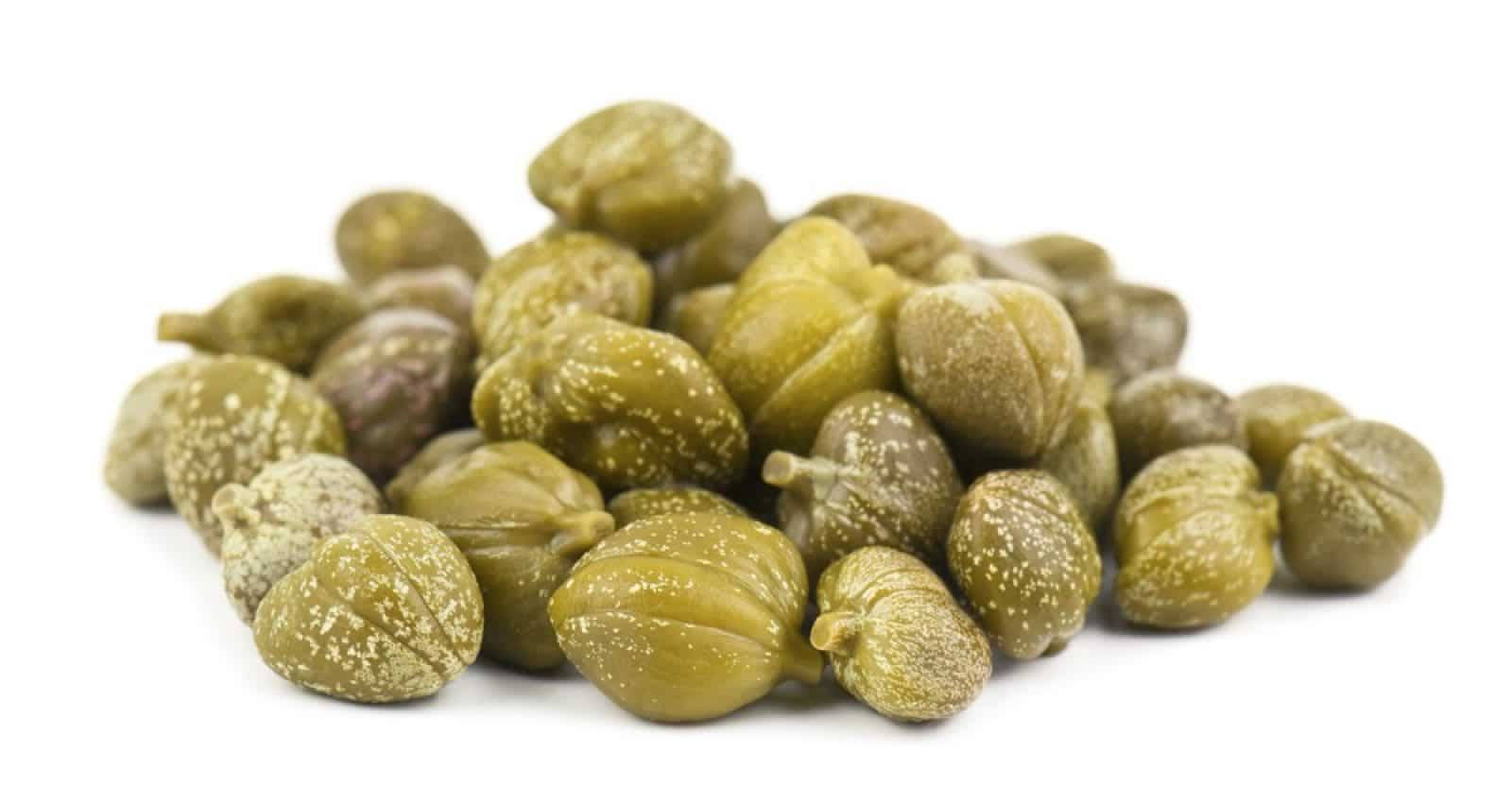 Fruit 桌布 壁紙 — 一堆青綠酸豆的特寫，帶有鹽晶體，襯托在純白背景上。