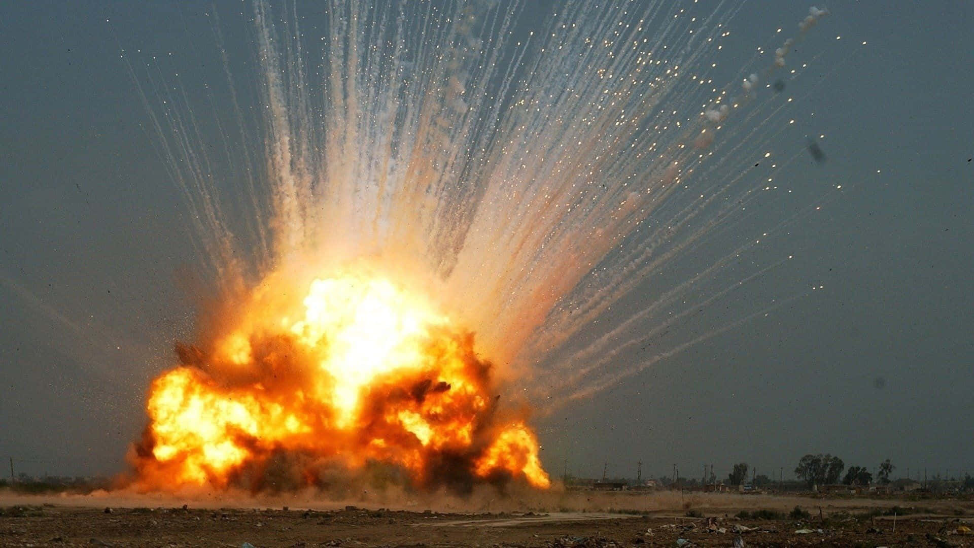 Blast 桌布 壁紙 — 一場巨大的猛烈爆炸從地面爆發，將明亮的橙色火焰和白色火花向上噴射，映襯著朦朧的天空。