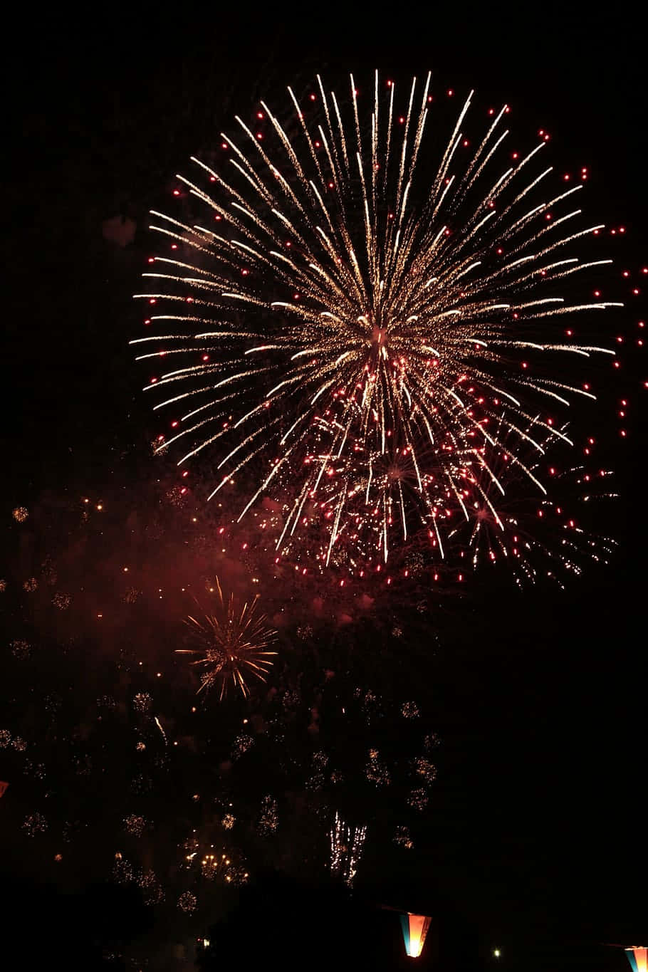 Fireworks 桌布 壁紙 — 一場耀眼的煙火爆炸，在漆黑的夜空中綻放出鮮豔的紅色和金色。
