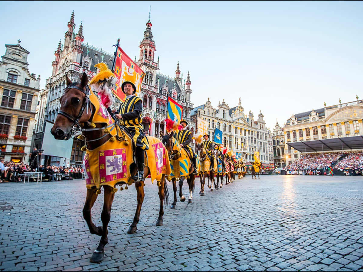 Europe 桌布 壁紙 — 一場色彩繽紛的騎士騎馬遊行，身穿華麗的黃色和紫色服裝，在黃金時段穿過歷史悠久的歐洲廣場。