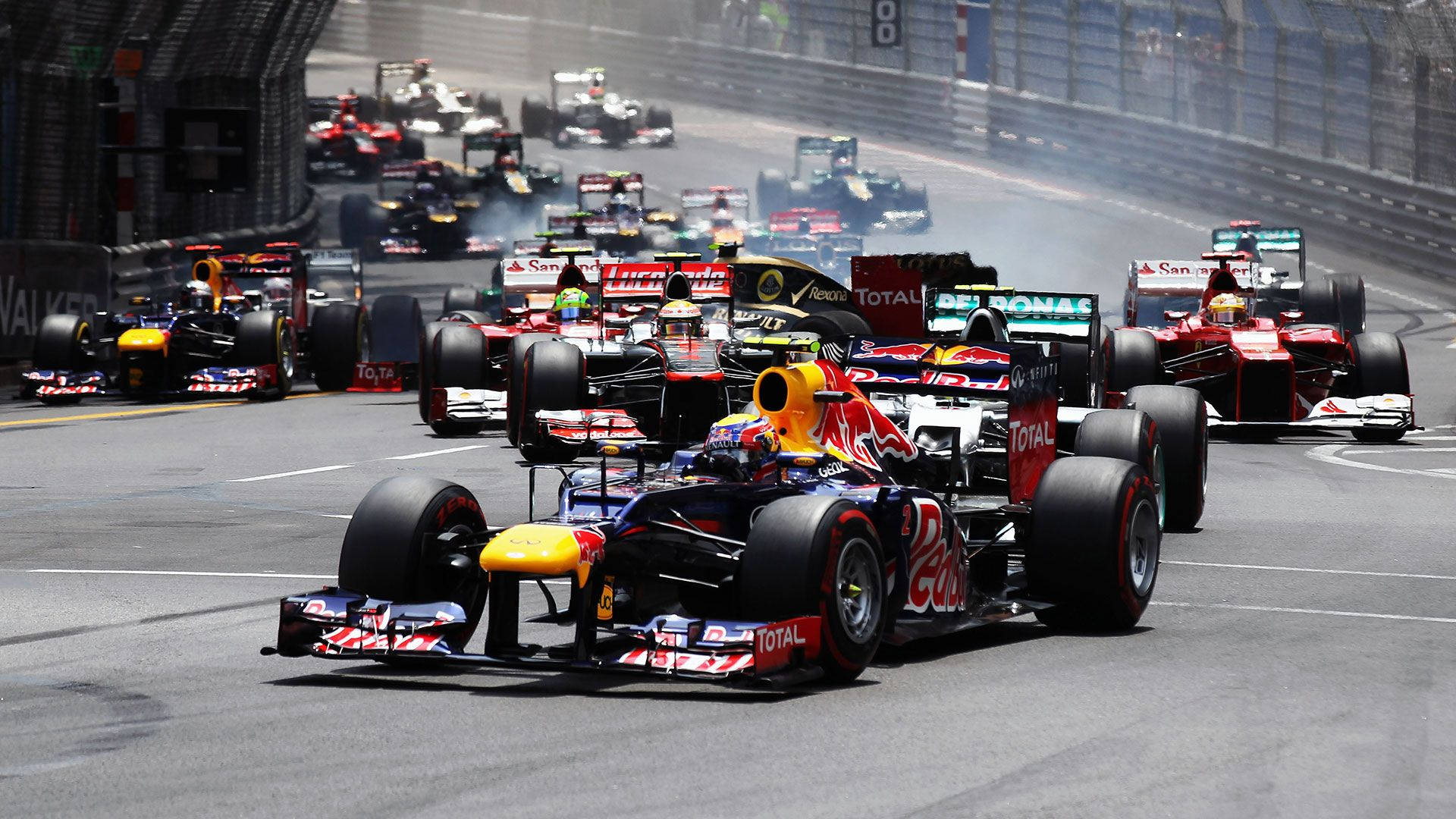Formula 1 Desktop 桌布 壁紙 — 一場高速一級方程式賽車，紅牛和法拉利賽車在陽光明媚的賽道上爭奪位置。