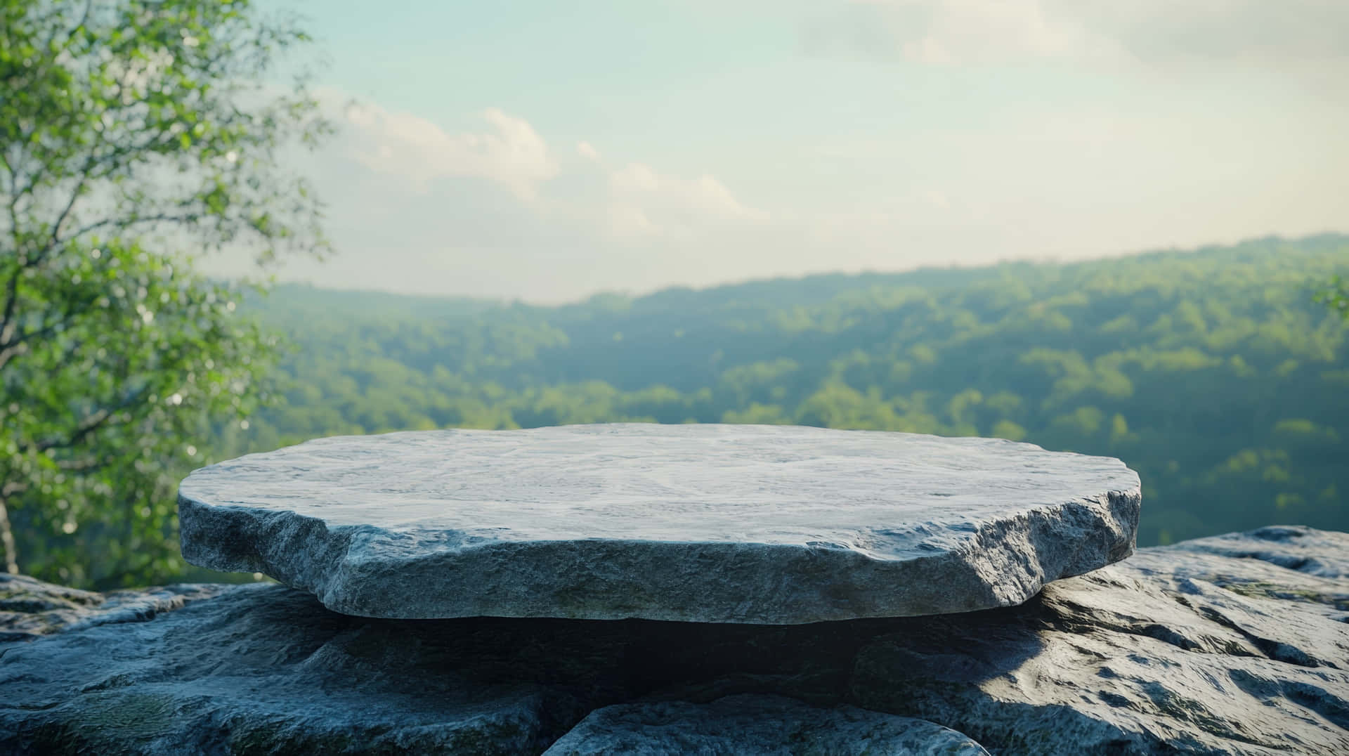 A large, round stone platform in the foreground offers a panoramic view of a lush green valley 壁紙 — 一塊光滑的灰色石板擱在堅固的岩石上，俯瞰著一片鬱鬱蔥蔥的綠色森林山谷，天空柔和湛藍。