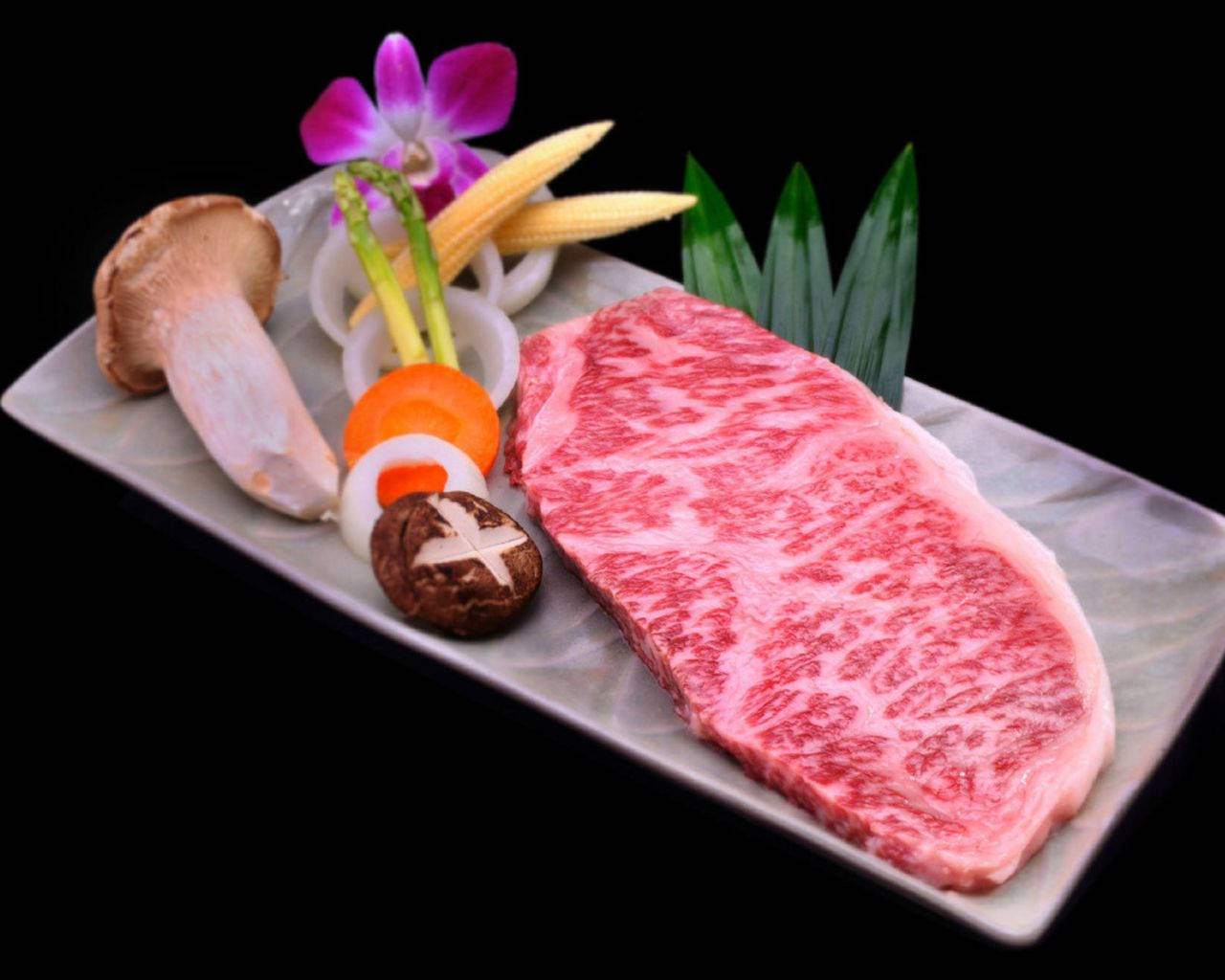 meat 桌布 壁紙 — 一塊奢華的日本和牛牛排，帶有複雜的雪花紋理，在黑色背景下藝術地擺盤，搭配蘑菇、玉米和裝飾。