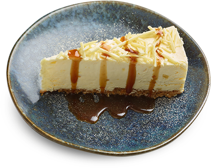 Cheesecake 桌布 壁紙 — 一塊奶油乳酪蛋糕，淋上焦糖醬和烤杏仁，放在一個有斑點的藍色盤子上。