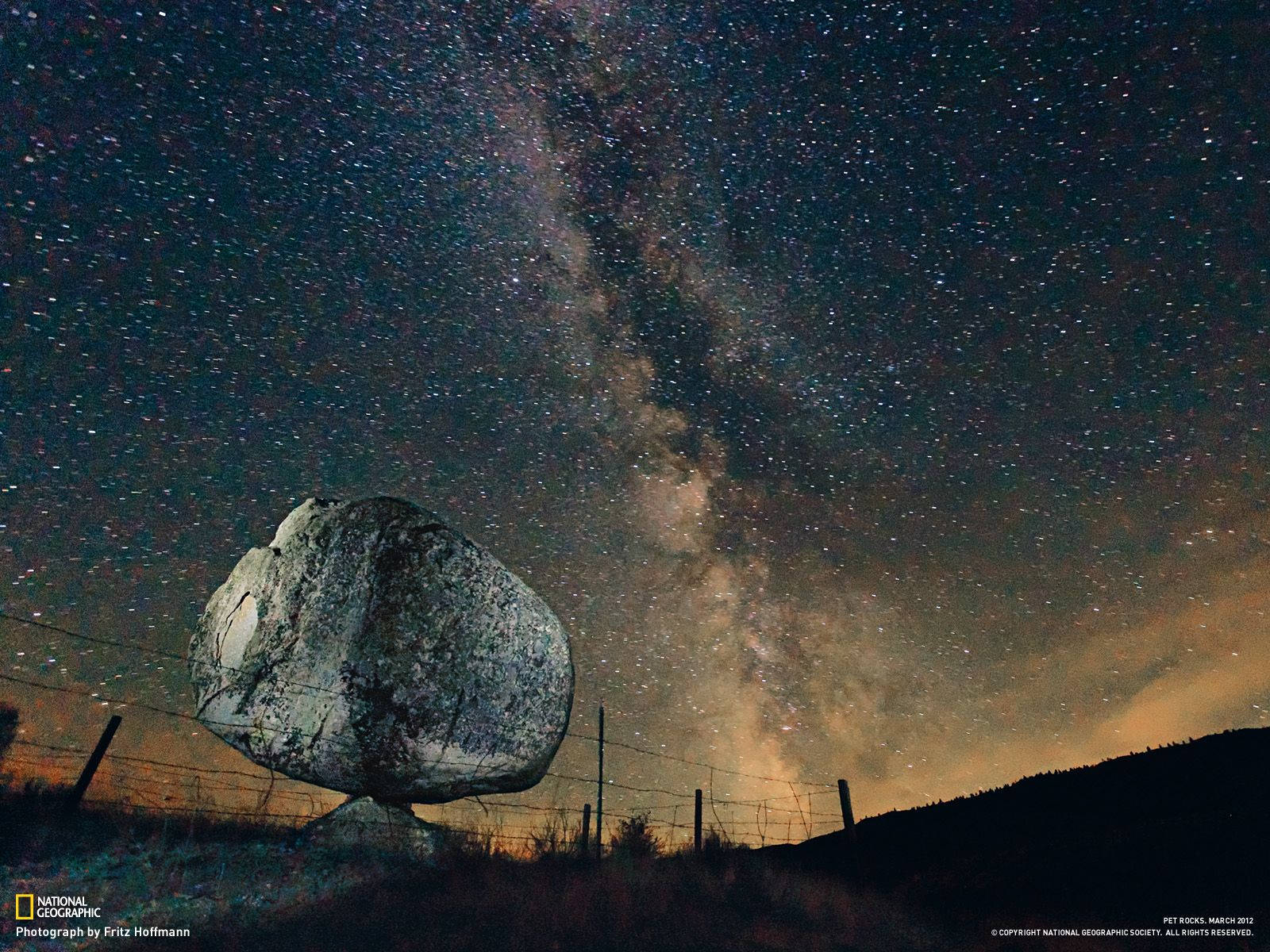 在繁星點點的夜空下，一塊巨大的平衡岩石，銀河清晰可見。 — 國家地理 壁紙