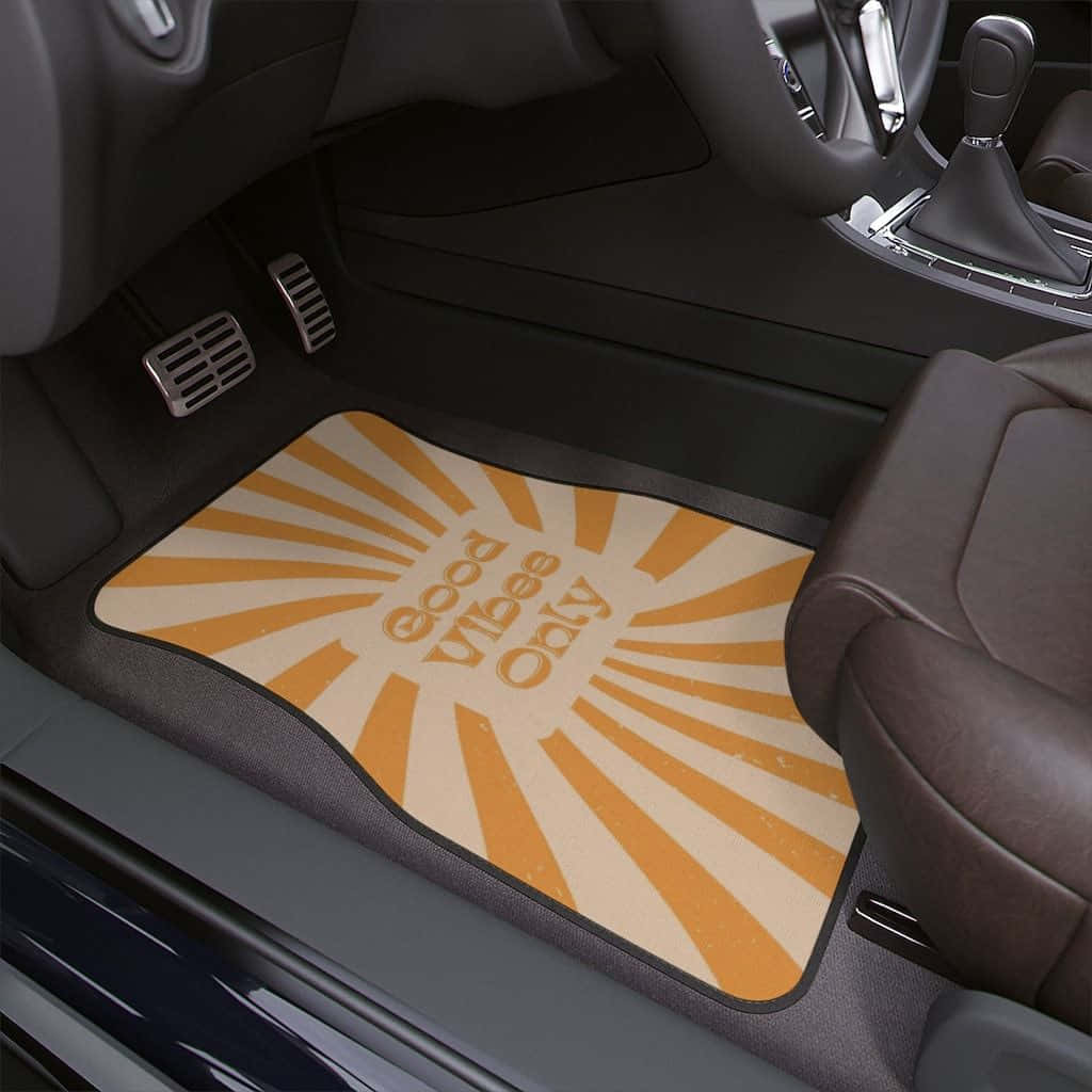 Minimalist Car 桌布 壁紙 — 一塊帶有太陽光線圖案及「good vibes only」文字的汽車腳踏墊，放置於現代汽車內裝的駕駛者腳踏空間中。