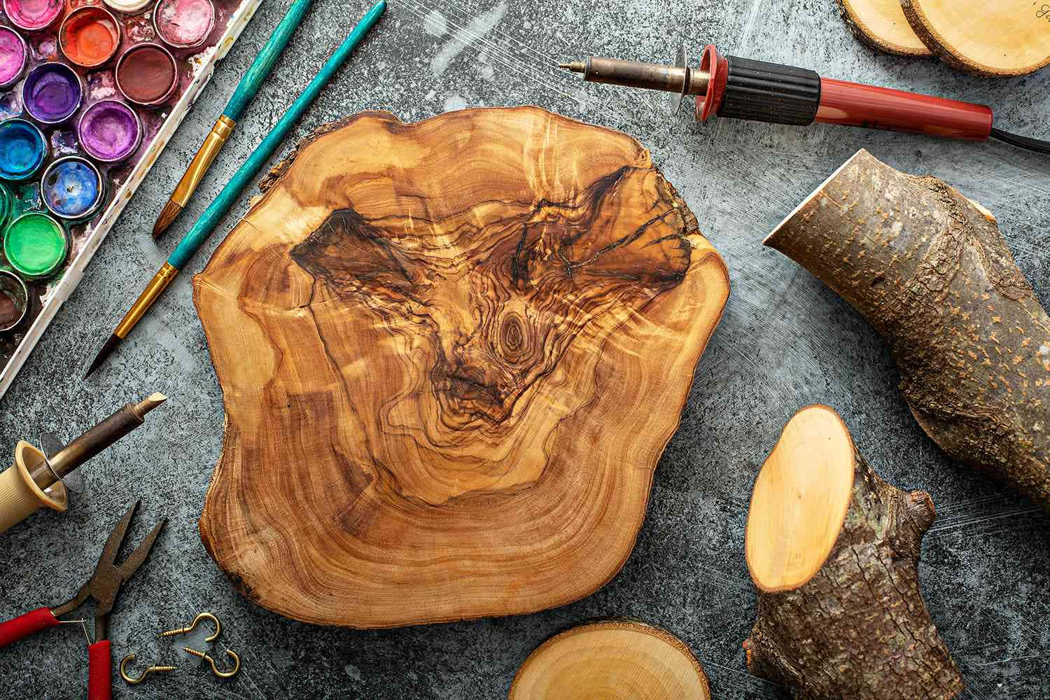 Wood Burning 桌布 壁紙 — 一塊帶有漩渦紋理的鄉村風格木片位於中央，周圍環繞著藝術用品和木工工具，放置在帶有紋理的灰色表面上。