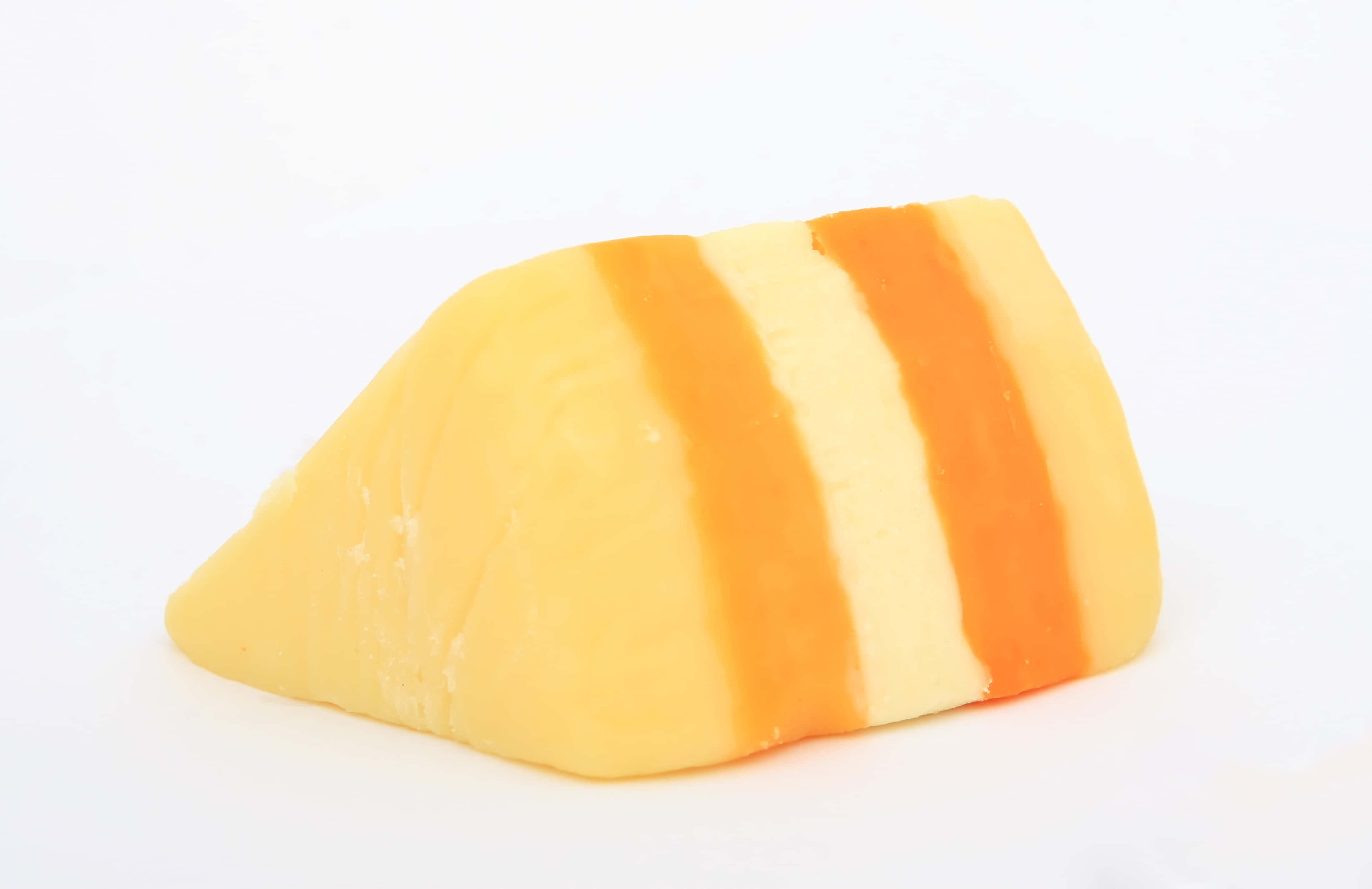 Cheese 桌布 壁紙 — 一塊帶有黃色和橙色交替條紋的起司楔形塊，孤立地放在純白色背景上。