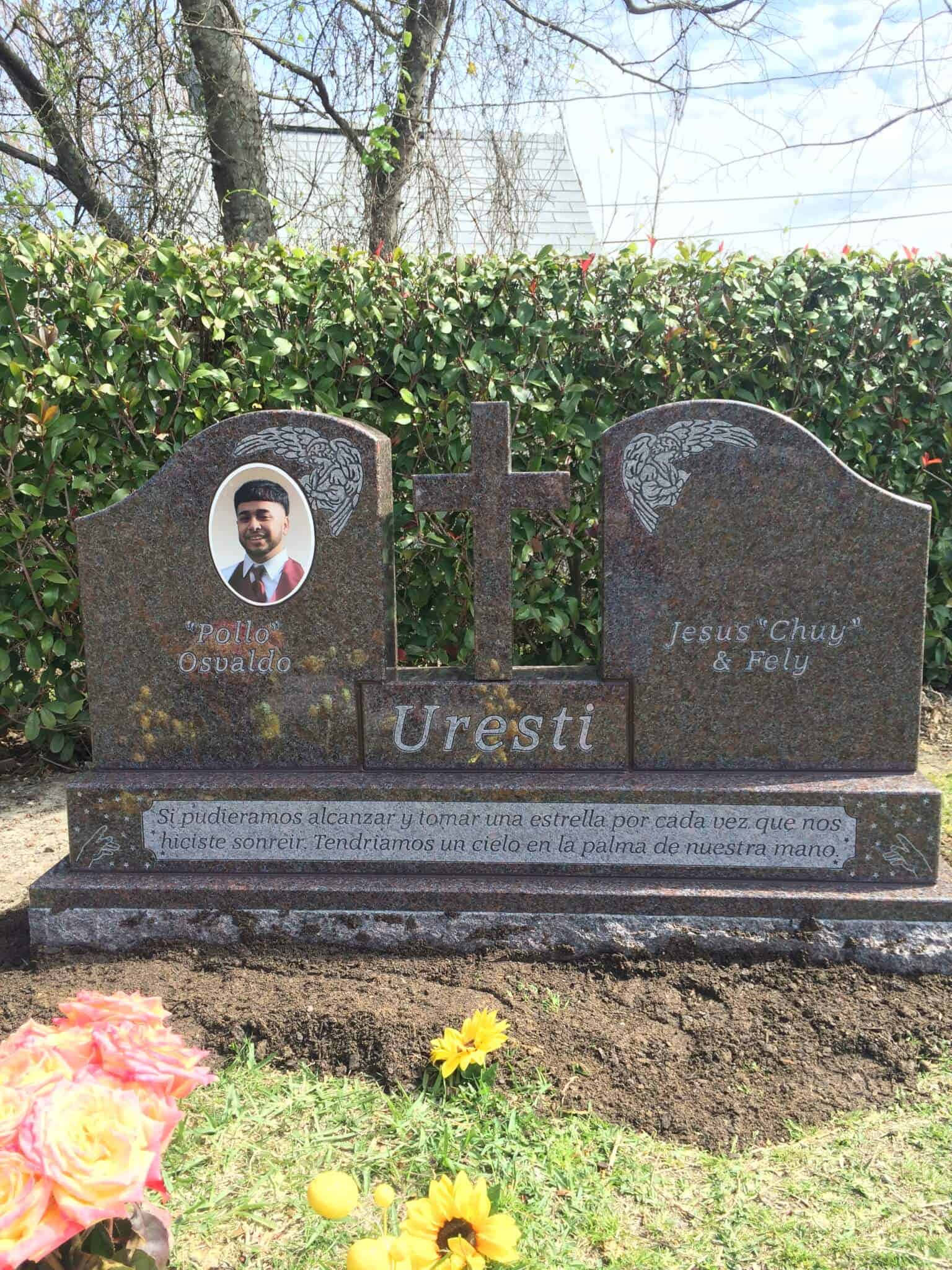 Memorial 桌布 壁紙 — 一塊拋光花崗岩雙人墓碑，刻有名字、照片和十字架，矗立在草地墓園中，周圍環繞著綠色樹籬和鮮花。