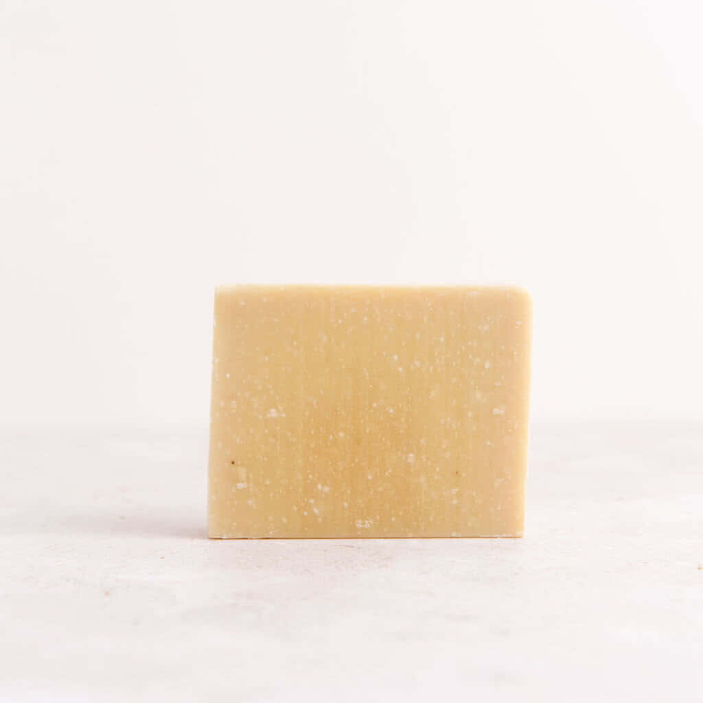 bath 桌布 壁紙 — 一塊淡黃色帶白色斑點的手工皂直立於潔白表面上。