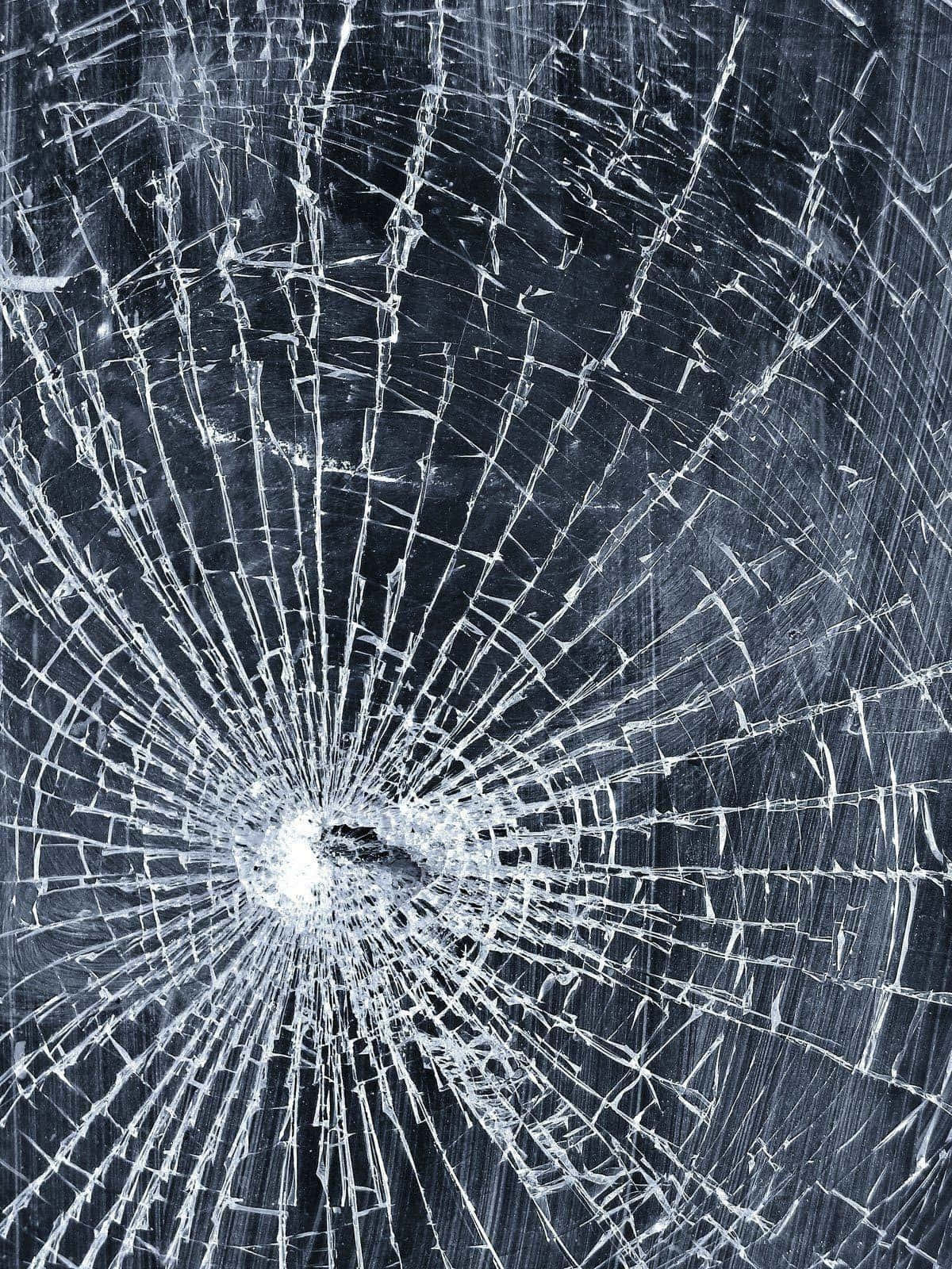 iPhone 桌布 壁紙 — 一塊破碎的玻璃表面，中央撞擊點在深色背景上散發出複雜的裂紋。