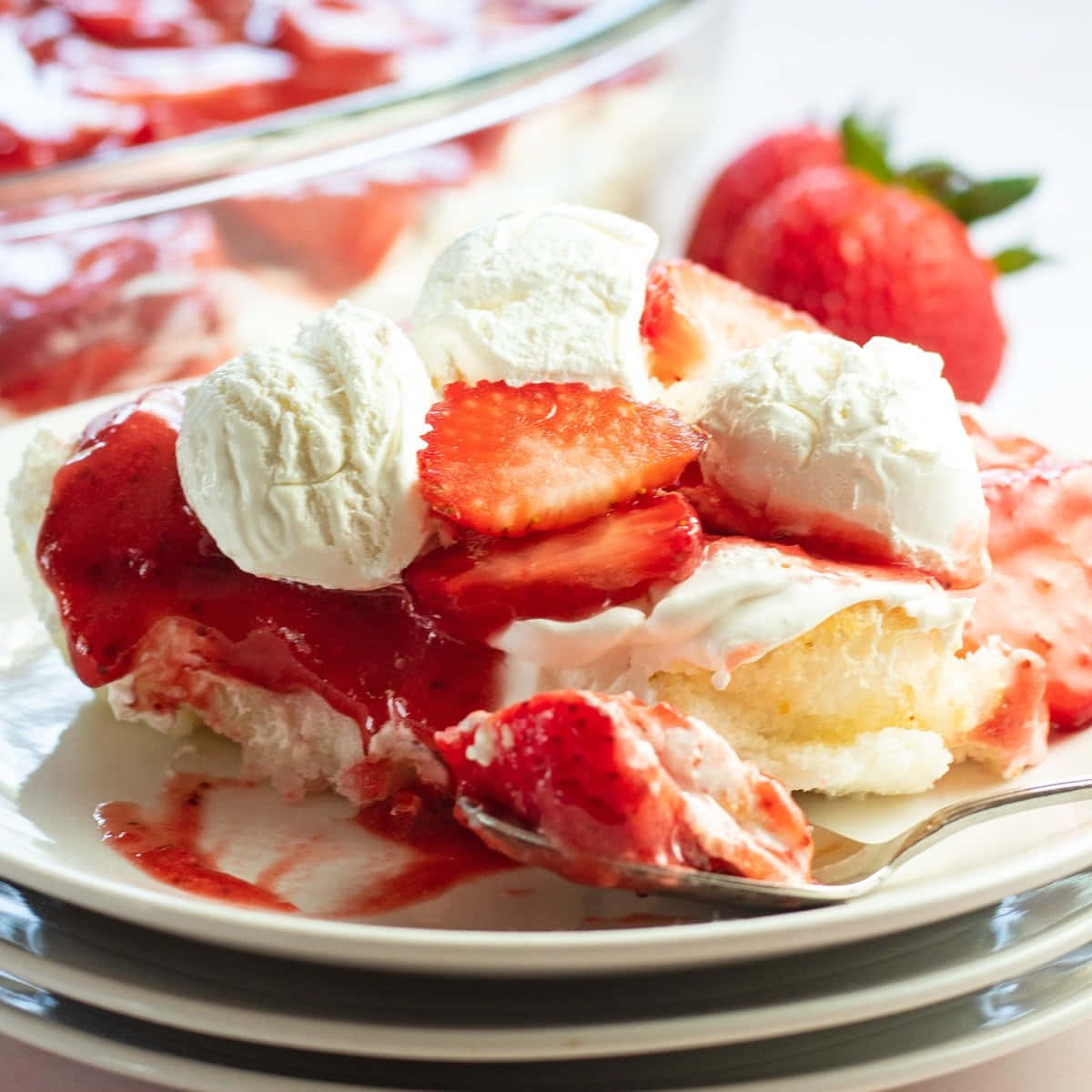 Strawberries 桌布 壁紙 — 一塊草莓脆餅的特寫，上面有鮮奶油和新鮮草莓，放在白色盤子上。