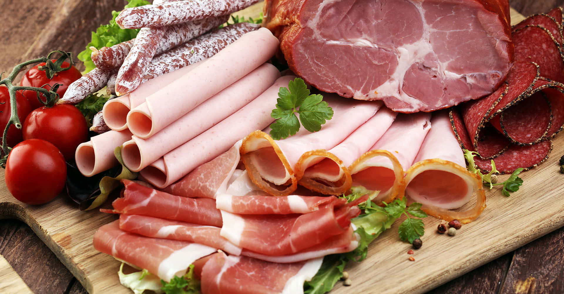 meat 桌布 壁紙 — 一塊質樸的木板上展示著令人垂涎的各式醃肉和新鮮小番茄，並以歐芹點綴。