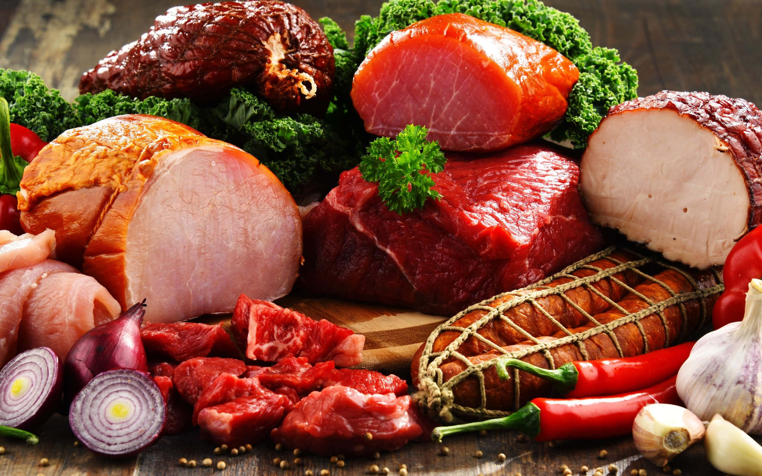 meat 桌布 壁紙 — 一塊質樸的木板上展示著各種生肉和醃製肉類，並以新鮮香草和鮮紅色的甜椒點綴。