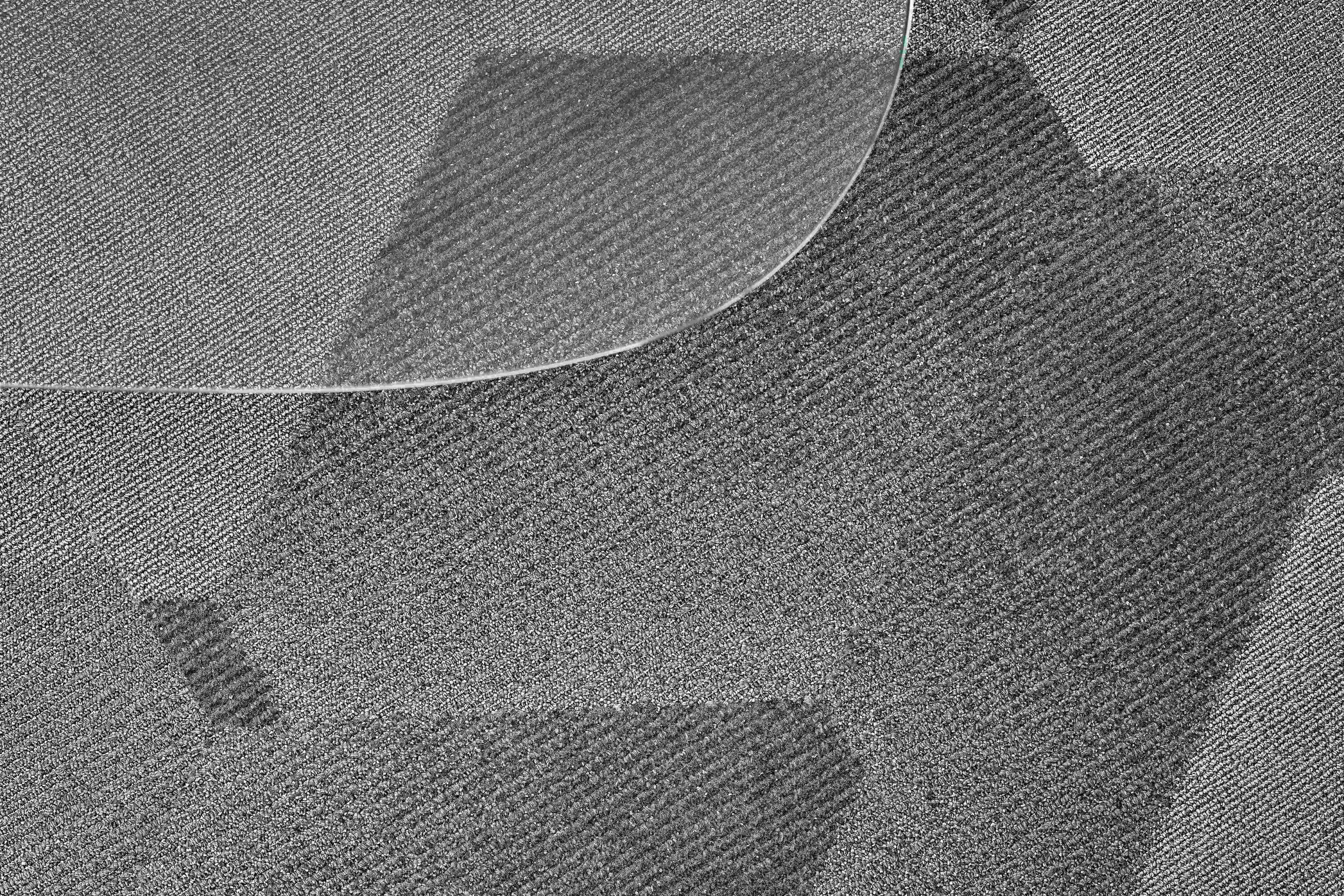 Gray Texture 桌布 壁紙 — 一塊透明彎曲玻璃片放置在帶紋理的灰色布料表面上的特寫。