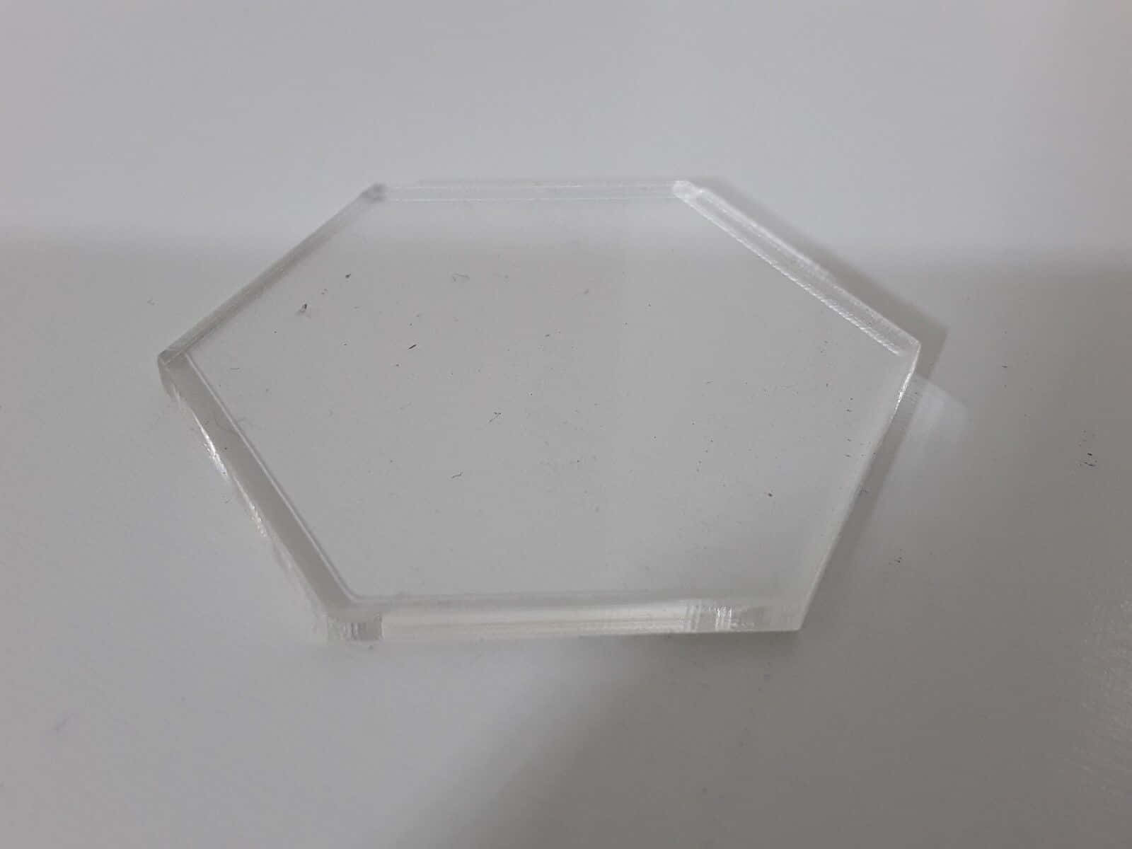 白色 桌布 壁紙 — 一塊透明的六角形壓克力瓷磚放在純白色表面上，投射出柔和陰影。