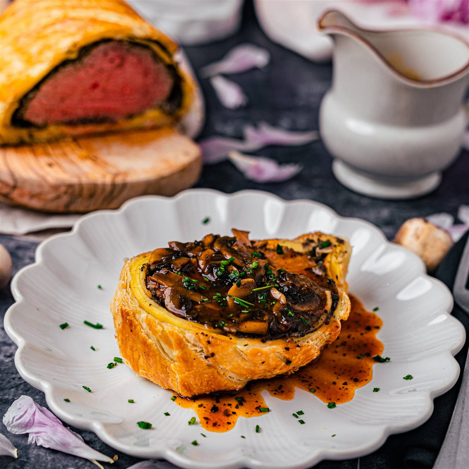 meat 桌布 壁紙 — 一塊金黃色的威靈頓牛排，配上蘑菇醬和巴西里，放在白色扇貝邊盤子上。