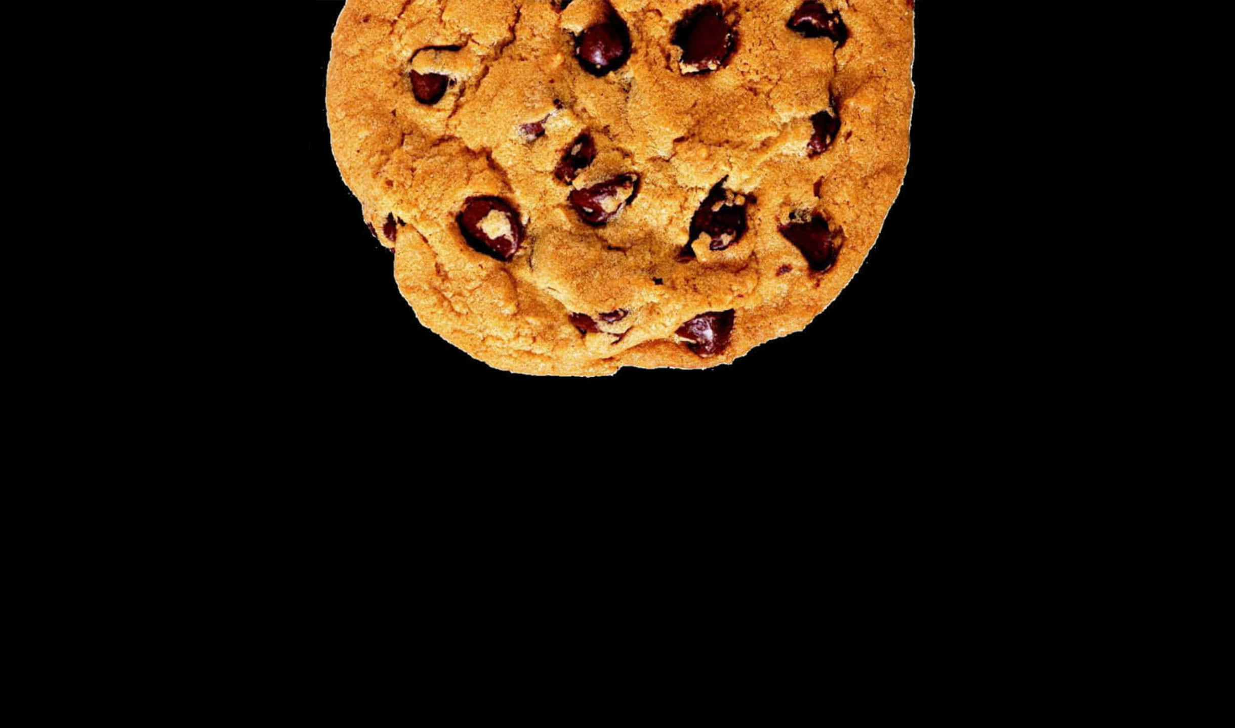 Cookie 桌布 壁紙 — 一塊金黃色的巧克力曲奇，帶有融化的巧克力塊，漂浮在純黑背景上。